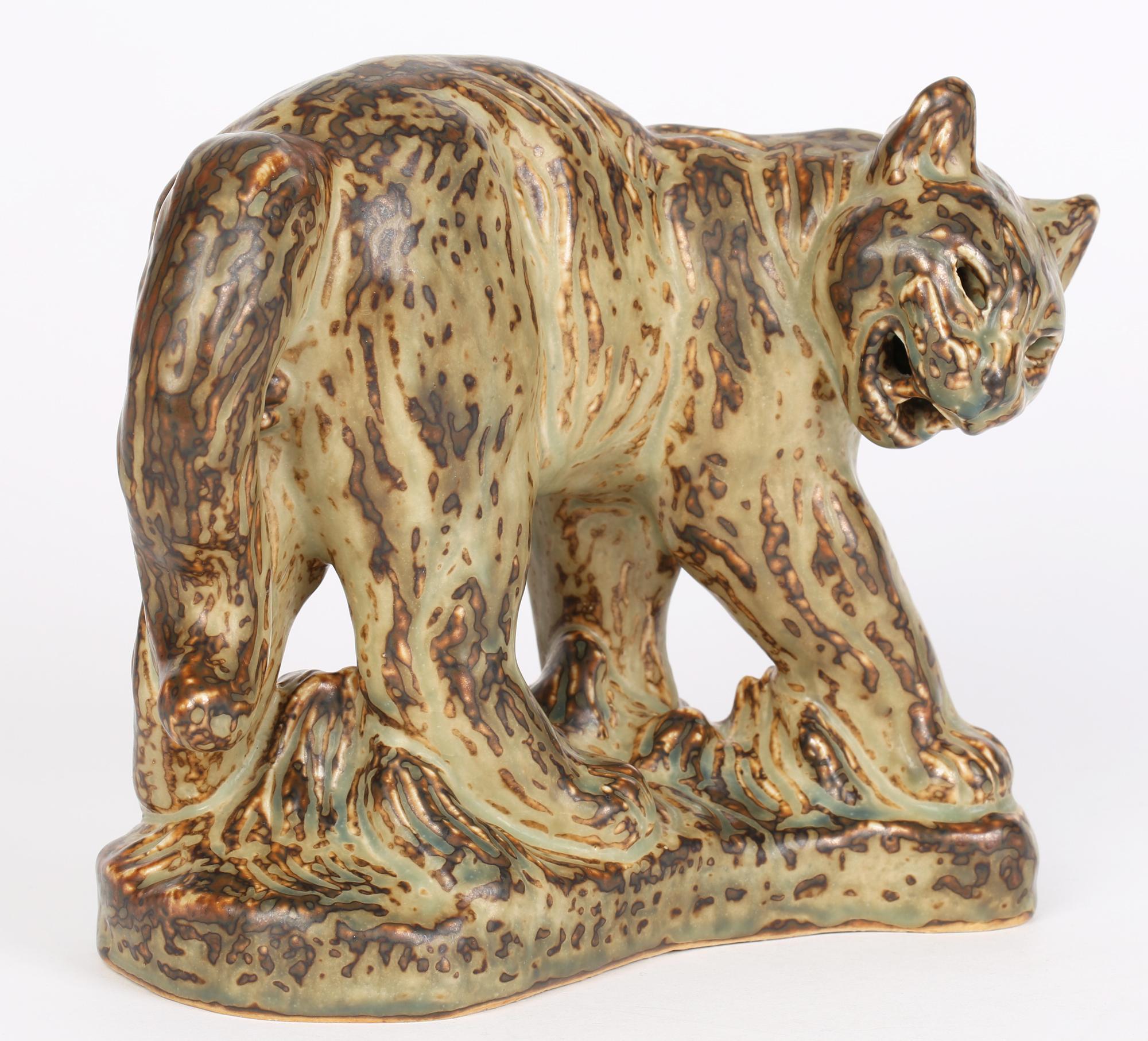 A large and stunning Danish Royal Copenhagen porcelain sculptural figure of a Puma by renowned animal artist Khud Kyhn (Danish, 1880-1969) conceived around 1935. The heavily made sculpture stands raised on a crescent shaped molded base and stands in
