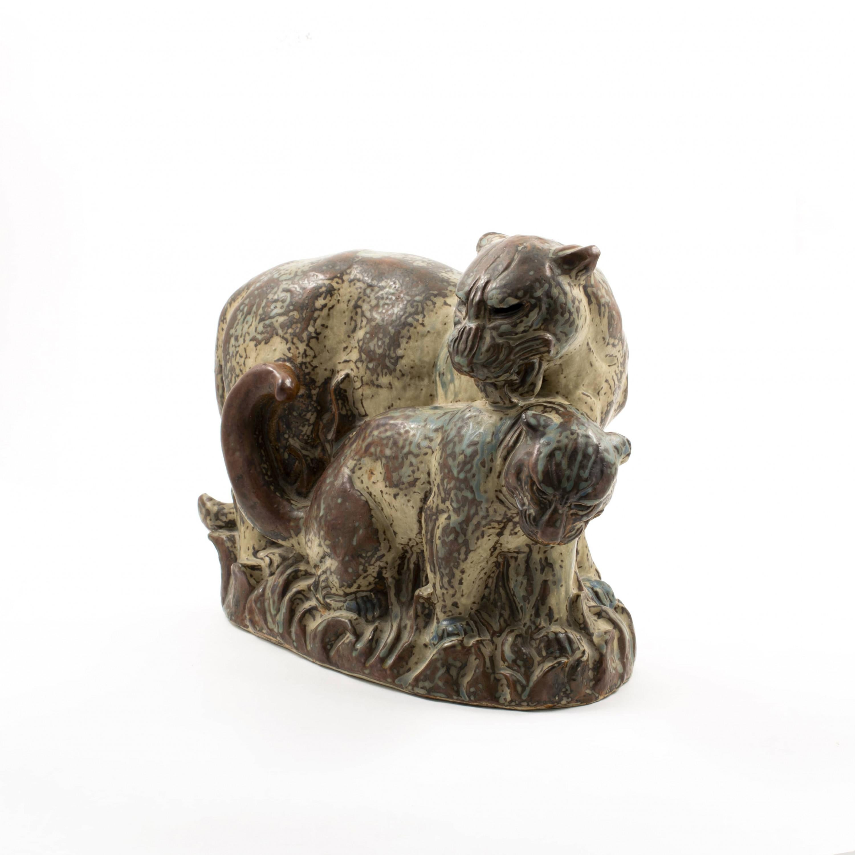 Knud Kyhn for Royal Copenhagen.
Glazed stoneware figurine of a panther with young cub, decorated in a stunning sung glaze.
Signed KK (Knud Kyhn) and Royal Copenhagen stamp, No. 20265. Denmark 1950's.

Knud Kyhn (1880-1969) was one of Denmark's