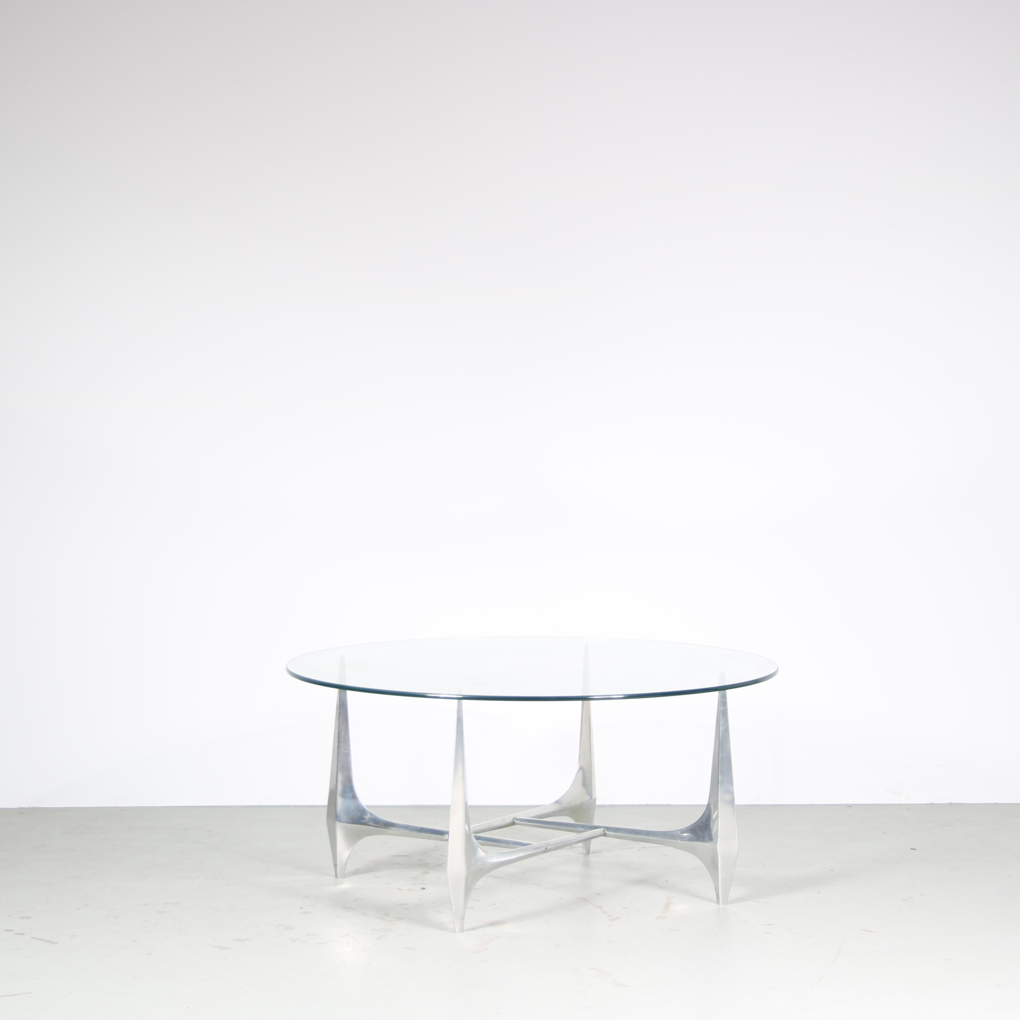 A beautiful coffee table, designed by Knut Hesterberg and manufactured by Ronald Schimdt in Germany around 1960.

This eye-catching table has an aluminium base, in elegant shape with each leg coming together in a beautiful square center. The round,