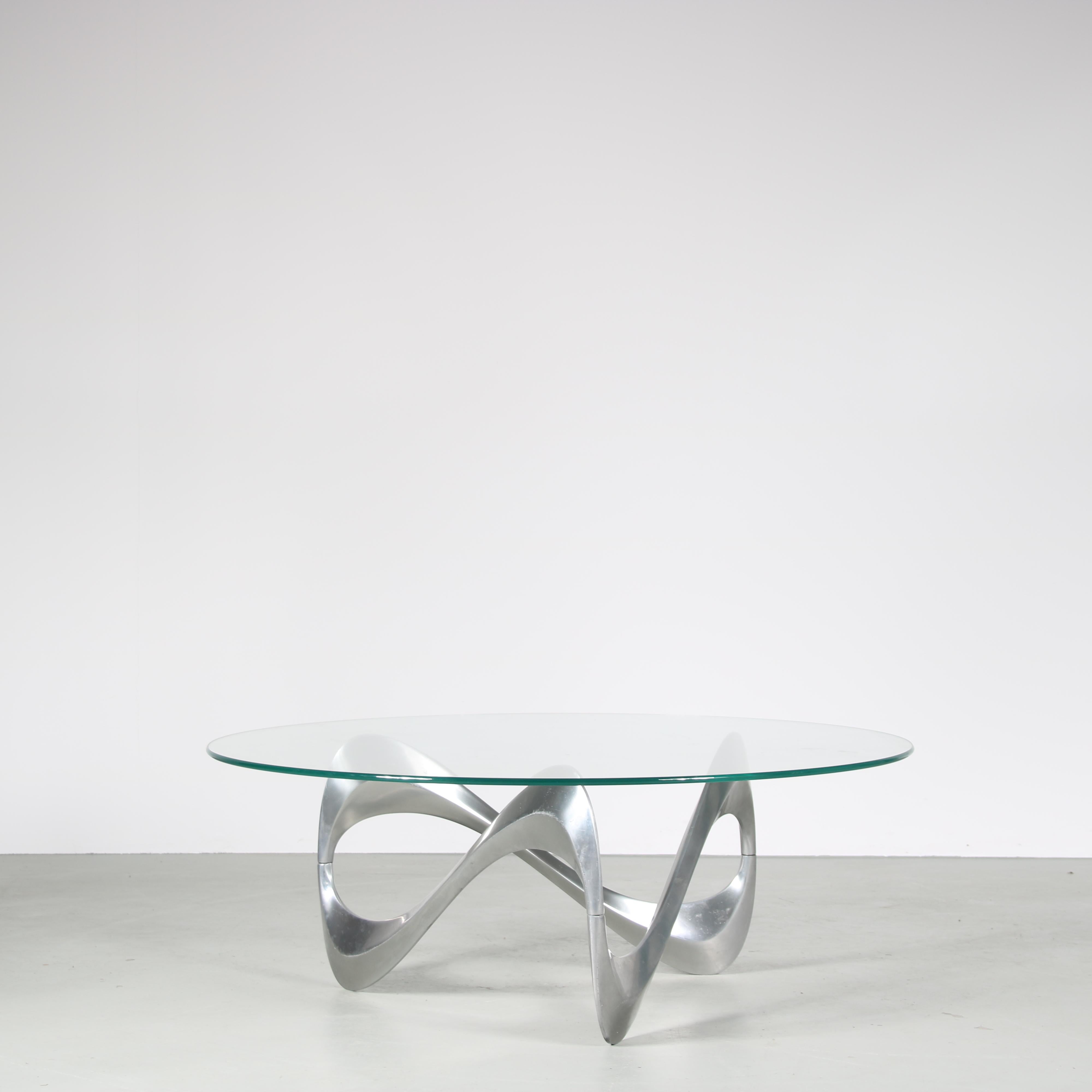 An iconic “Snake” coffee table, designed by Knut Hesterberg and manufactured by Ronald Schimdt in Germany around 1970.

This eye-catching table has an aluminium base, in eye-catching waved shape which it owes it’s name to. The round, clear glass