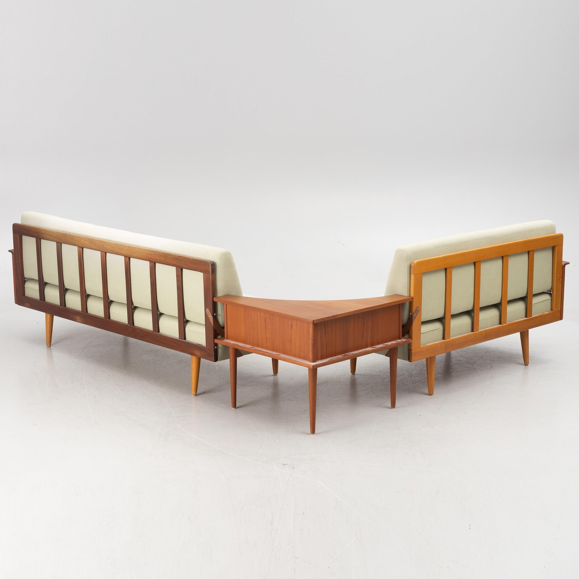 Corners sofa with table, model 610, Vatne Møbler AS, Norway.
Sofas with frames in teak and beech, as well as armrests in rattan. Fixed upholstered seat and loose cushions in the back. Corner table with an upper section in teak. Sofa, length