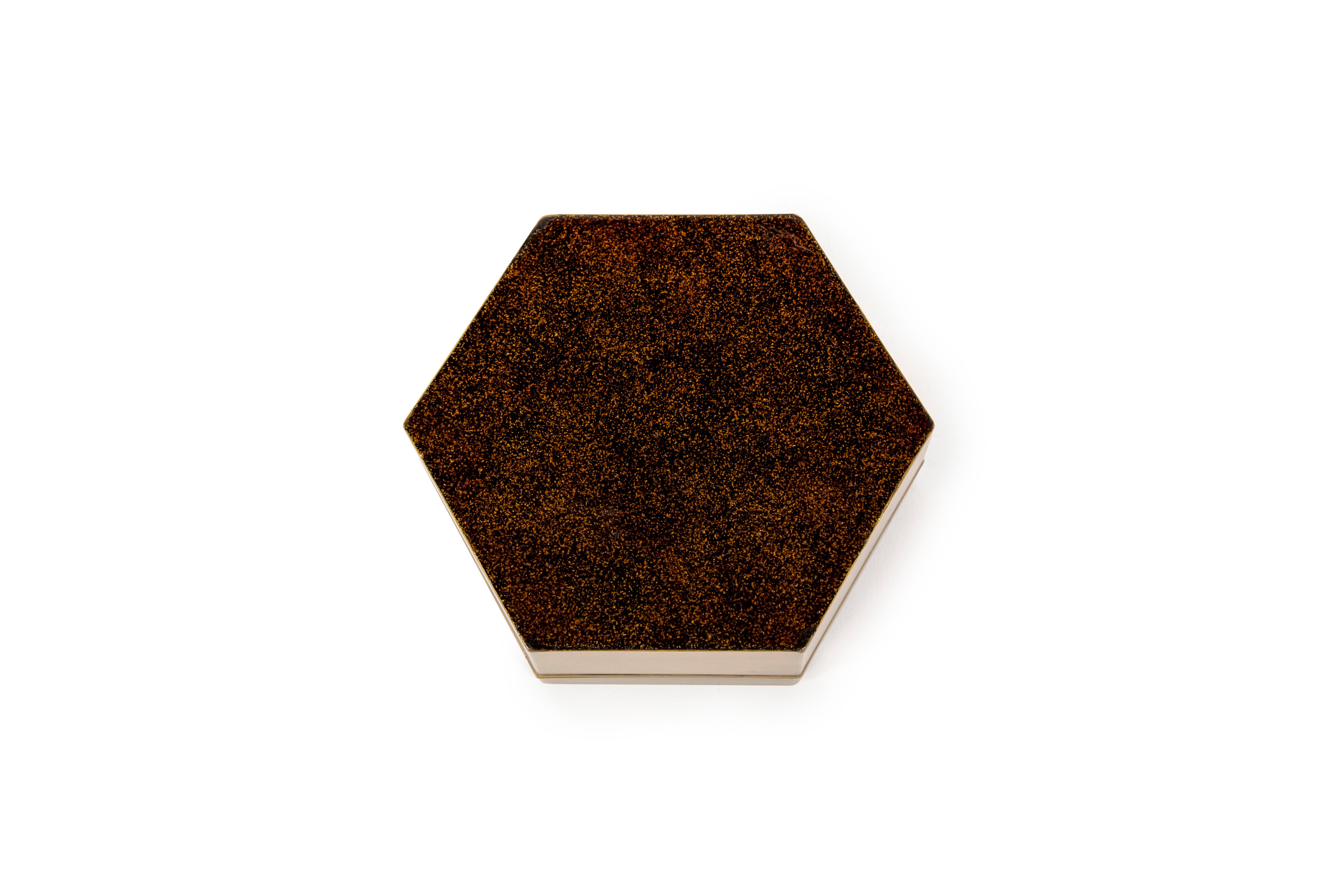 Dieses kleine sechseckige Kobako zeigt eine reiche Szene mit zwei Hähnen, die auf einer Kiefer inmitten einer üppigen Naturlandschaft sitzen. Die Seiten der Komposition sind mit Pfingstrosen und Chrysanthemen geschmückt, wobei jedes Element reich an