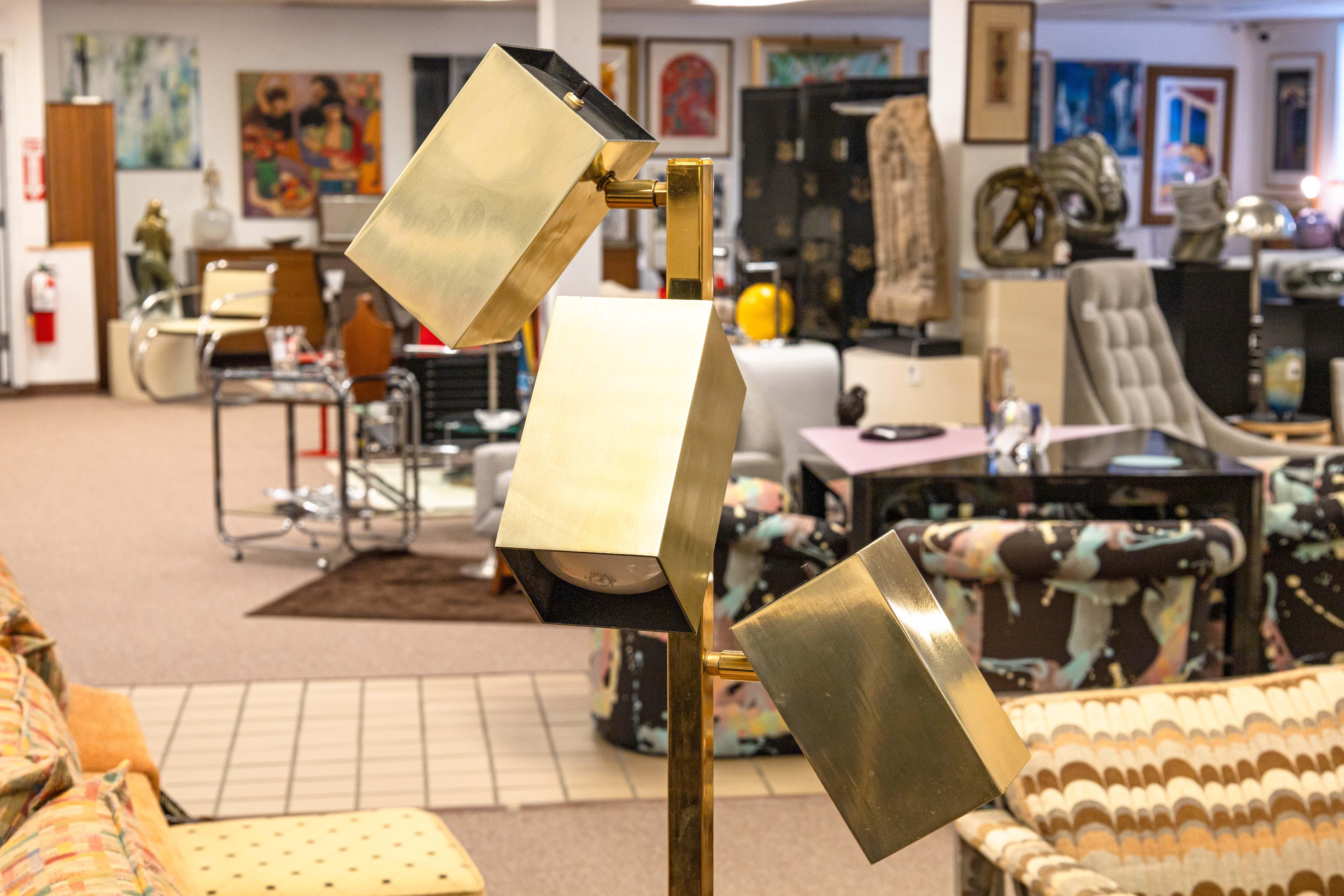 A Koch & Lowy adjustable 3 head floor lamp. This beautiful mid century modern piece features 3 rectangular heads which articulate in multiple positions. Each light head has a switch on the top to independently turn each light on and off. The heads