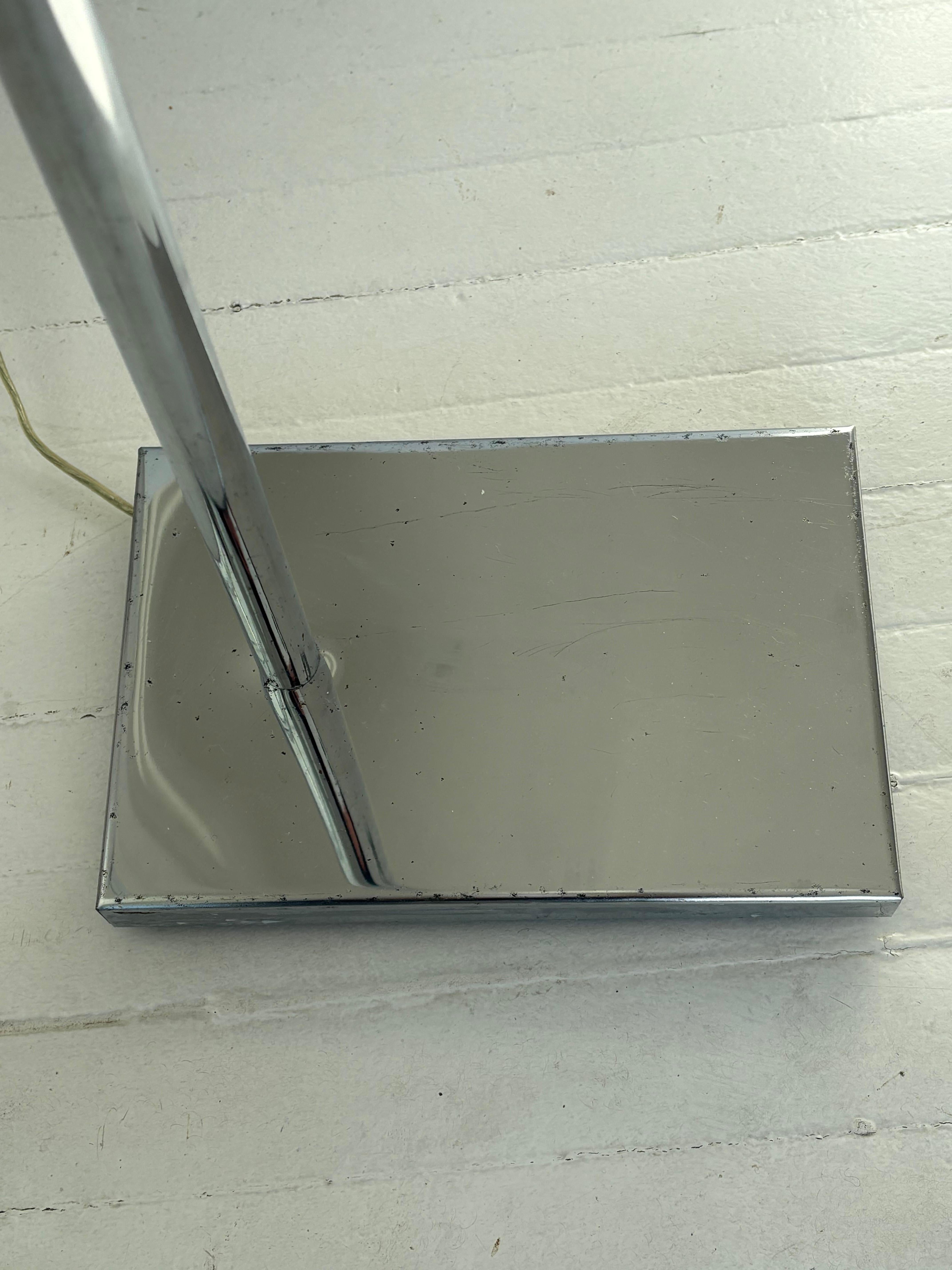 Lovely 1970s chrome floor lamp is adjustable in height and the triangular shade adjusts up and down and side to side . Very famous simple design sometimes called a pharmacy lamp . Marked OMI