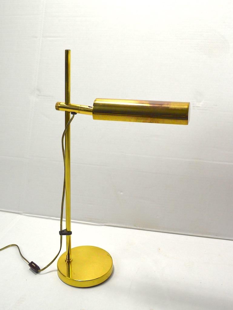 Classic 1970s adjustable brass desk lamp by Koch & Lowy. This example is adjustable in height and the brass hood shade will pivot as well, tom position the light exactly where needed. Then lamp shows some cosmetic wear to finish, specifically