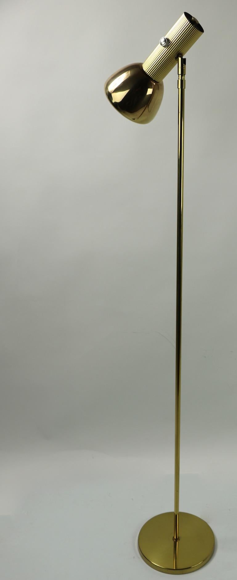 Brass floor lamp made by Koch and Lowy for OMI. The lamp has an adjustable hood shade which will tilt and pivot to direct the light. Measures: Lamp shade 8.5 length x 4.5 inch diameter. Signed example, clean working and ready to use.