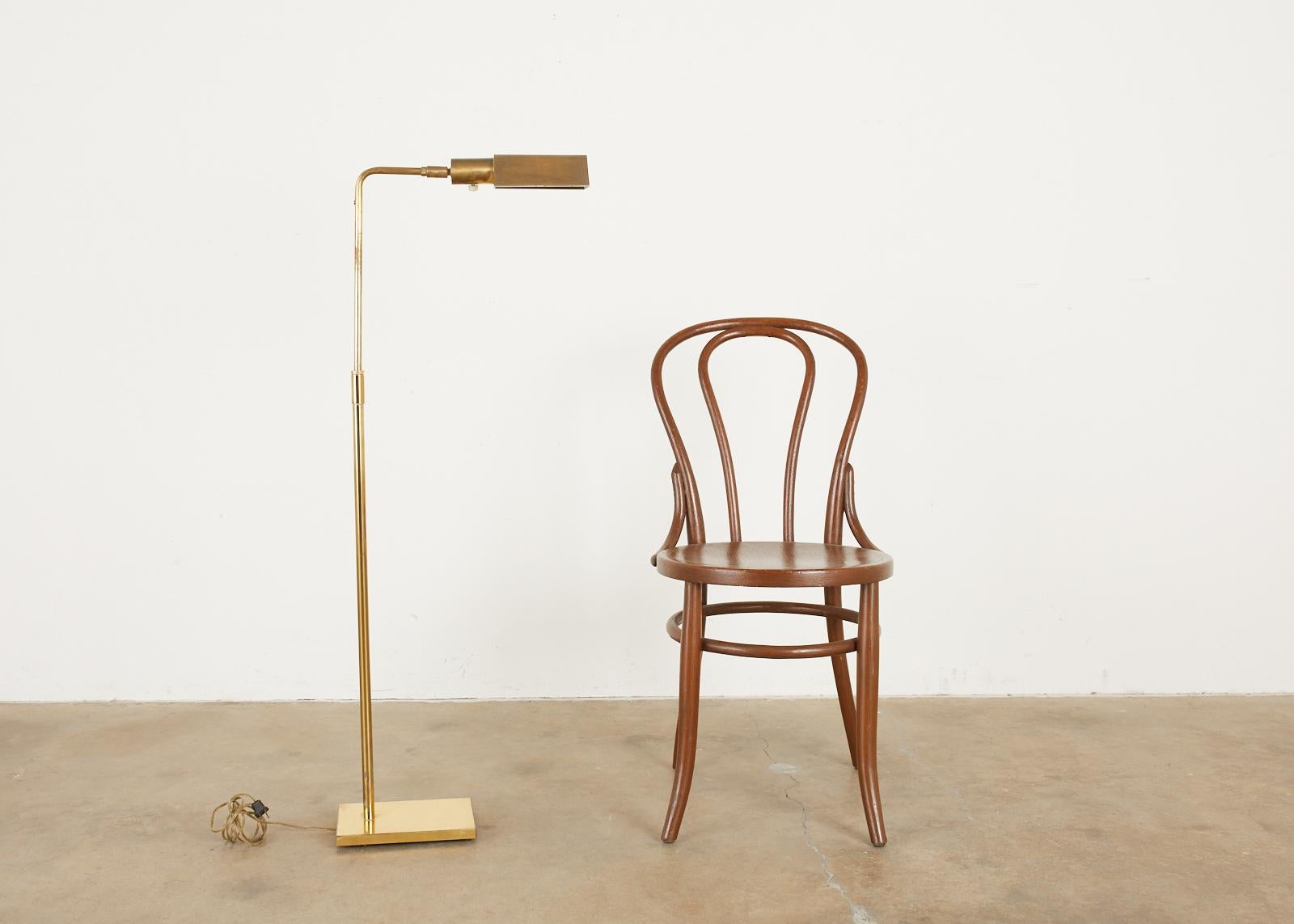 Patinated midcentury pharmacy floor lamp or reading lamp made by Koch & Lowy. The lamp has a swivel adjustable head and a height adjusting neck. Iconic profile and design with a rich, aged patina on the brass.