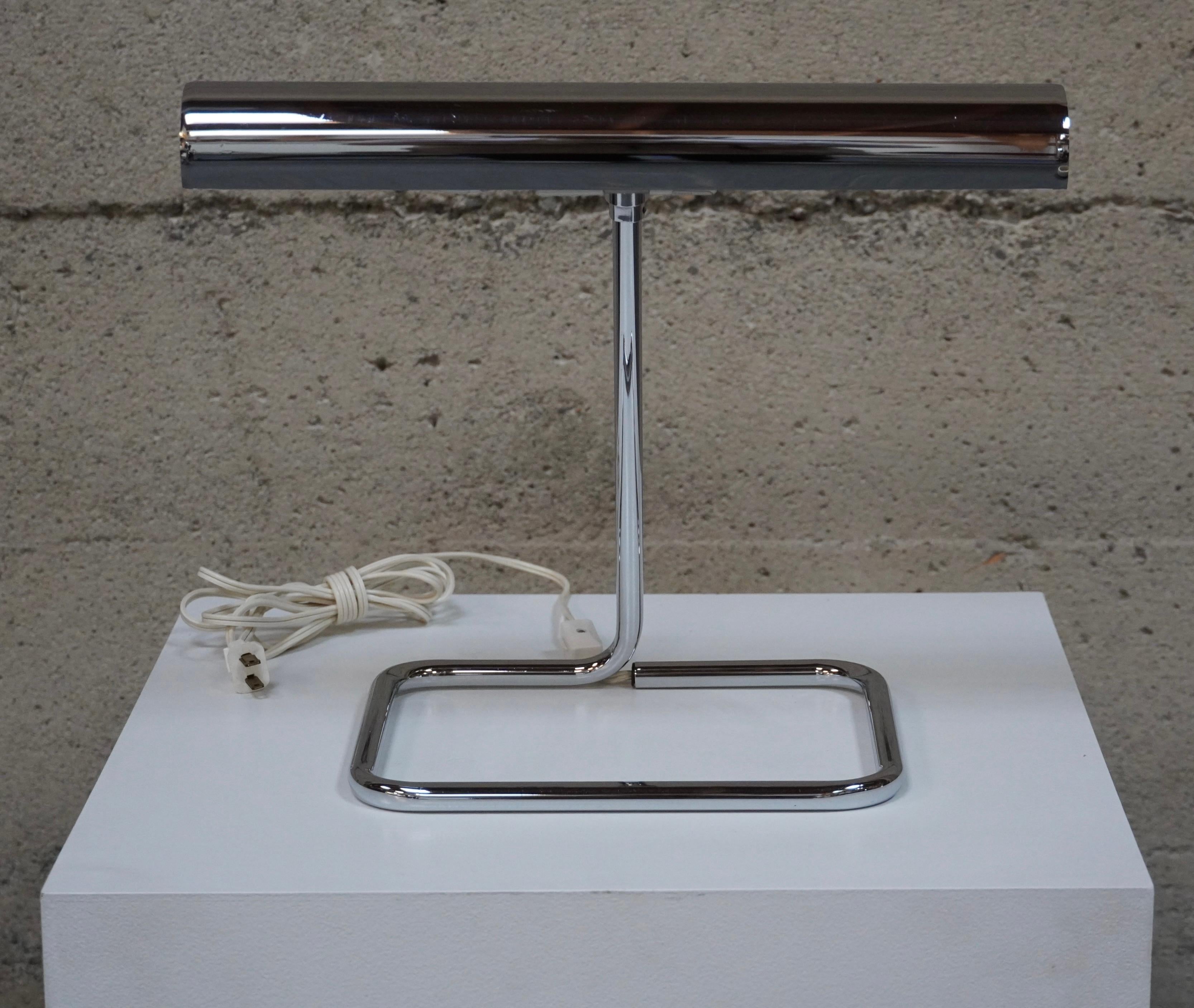 Modernist chrome plated table lamp by Koch & Lowy circa 1970s, U.S.A. The rectangular shade houses two ceramic sockets for the light bulbs and is controlled by a inline switch at the base of the square formed tubular base. The shade has some