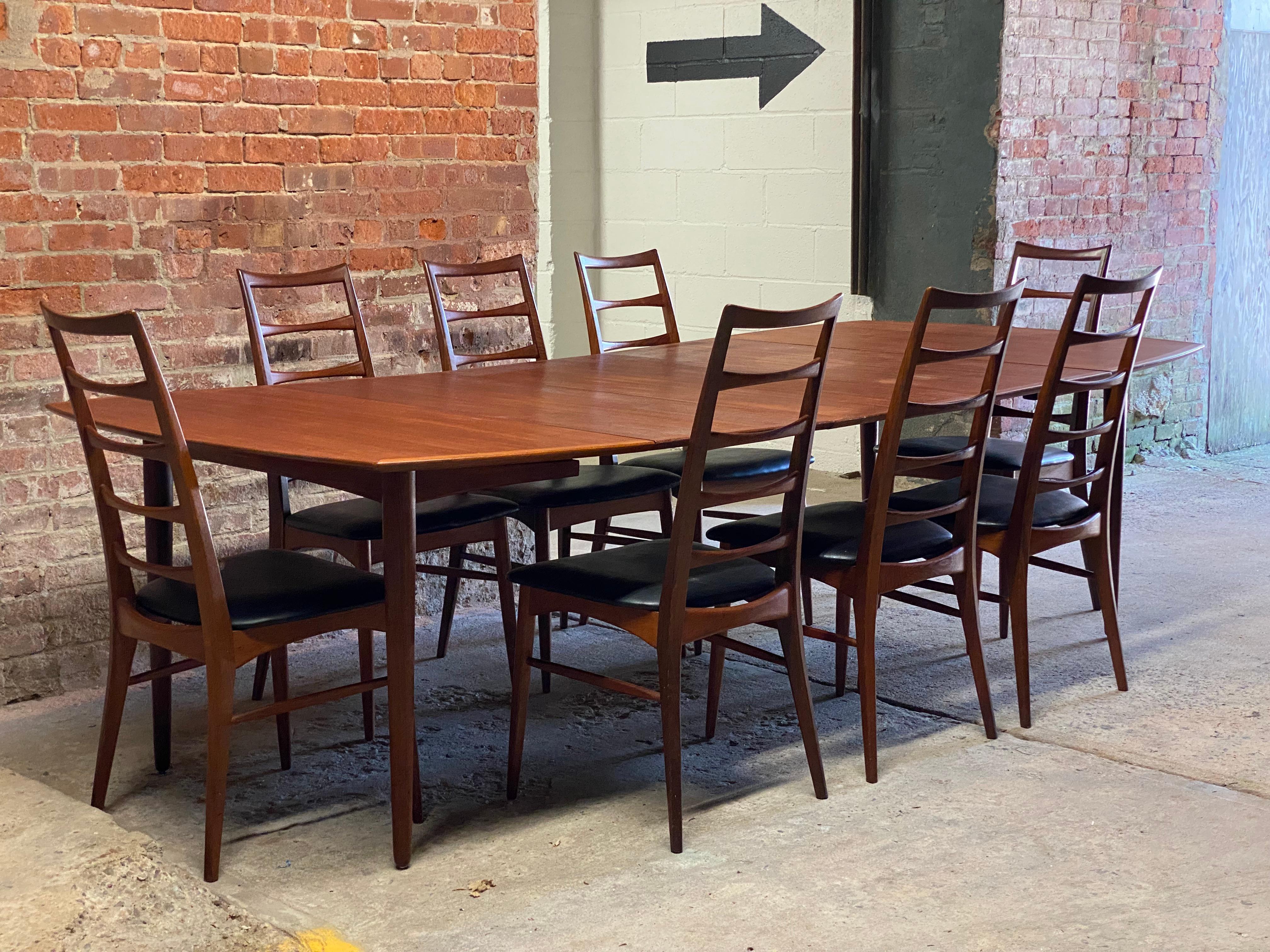 Kofoed Hornslet teak dining table and eight (8) dining chairs. Originally purchased at Bloomingdale's. The dining table can be used with no leaves, one, two or three. Featuring a banded edge, nicely figured teak top veneers, a nice arching accent