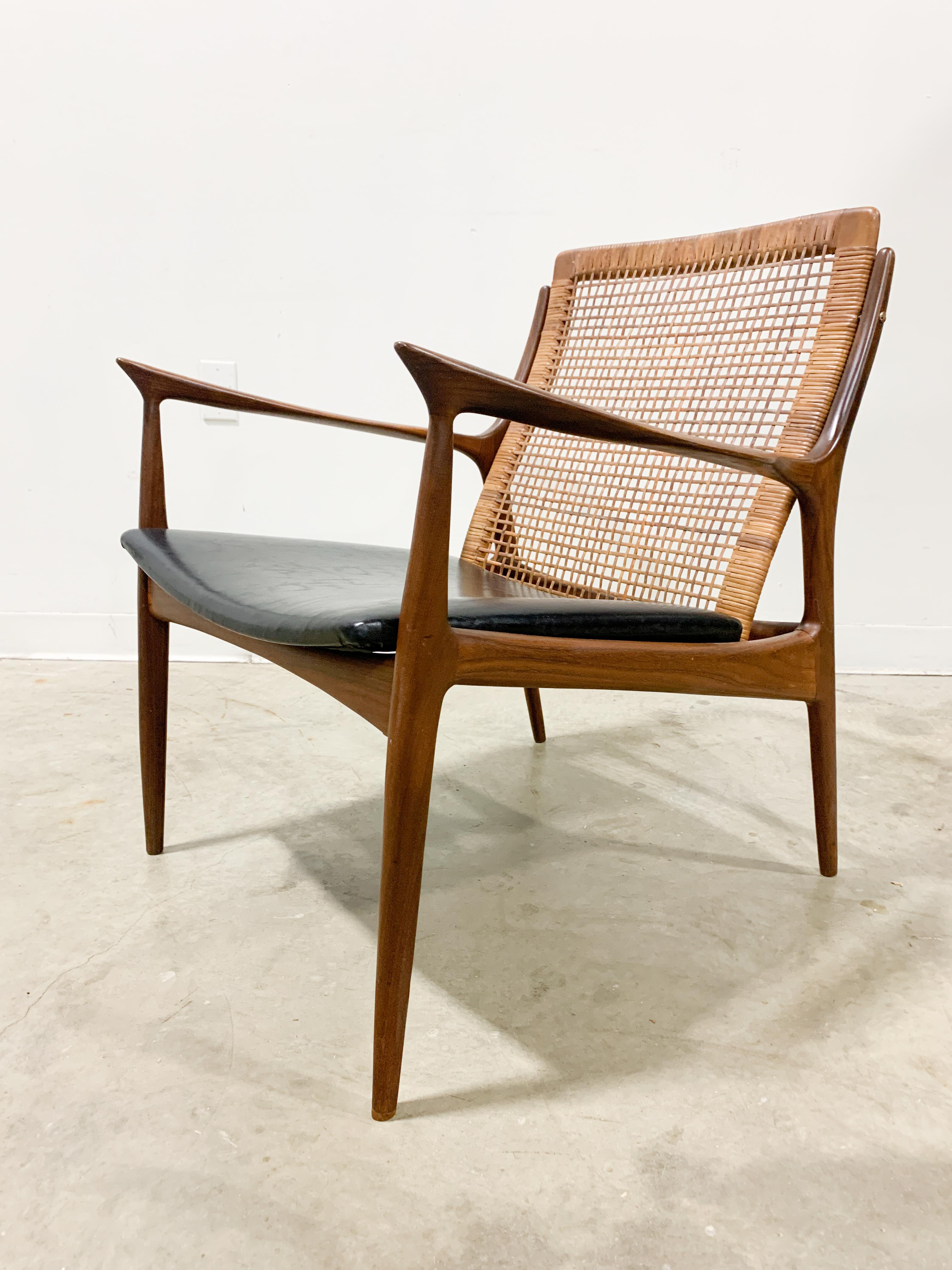 Exquisitely sculpted Model 18-15 chair designed by Ib Kofod-Larsen and made in Denmark from Afrormosia Teak. This design is a remarkable exercise in reduction as the frame has been pared down by the designer to the absolute minimum with sinuous