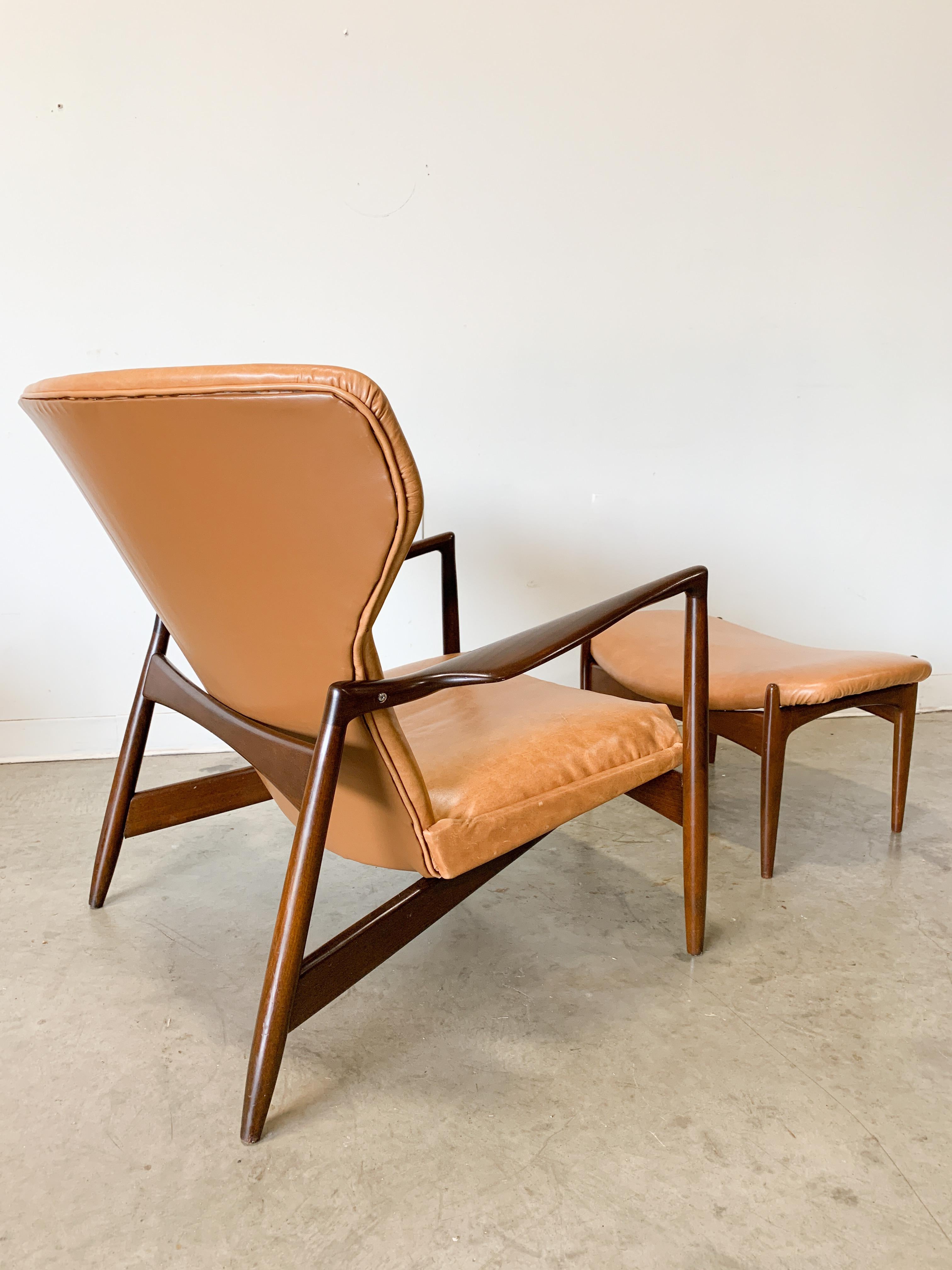 Striking Danish modern designs by Kofod Larsen for Selig. Beautifully sculpted frames of solid beech with a walnut tinted lacquer finish. New genuine leather upholstery and foam provide a very comfortable seat with excellent back support. This chair