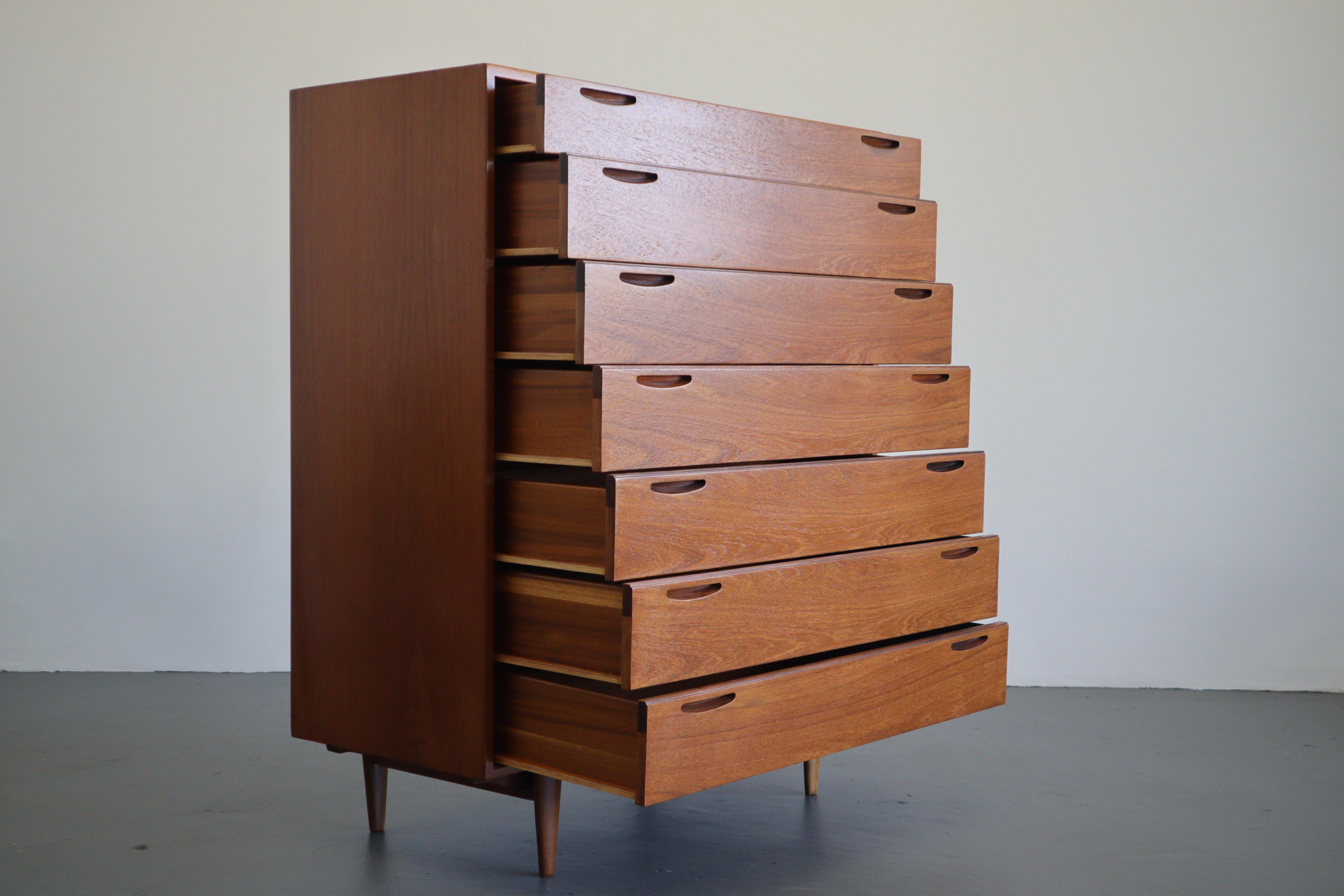 An exceptional Danish modern 7 drawer highboy by Kofod Larsen for Brande Mobelfabrik. Beautiful grain throughout front and back with no notable damage. This piece offers plenty of storage with sleek minimalist pulls The piece sits atop afrormosia