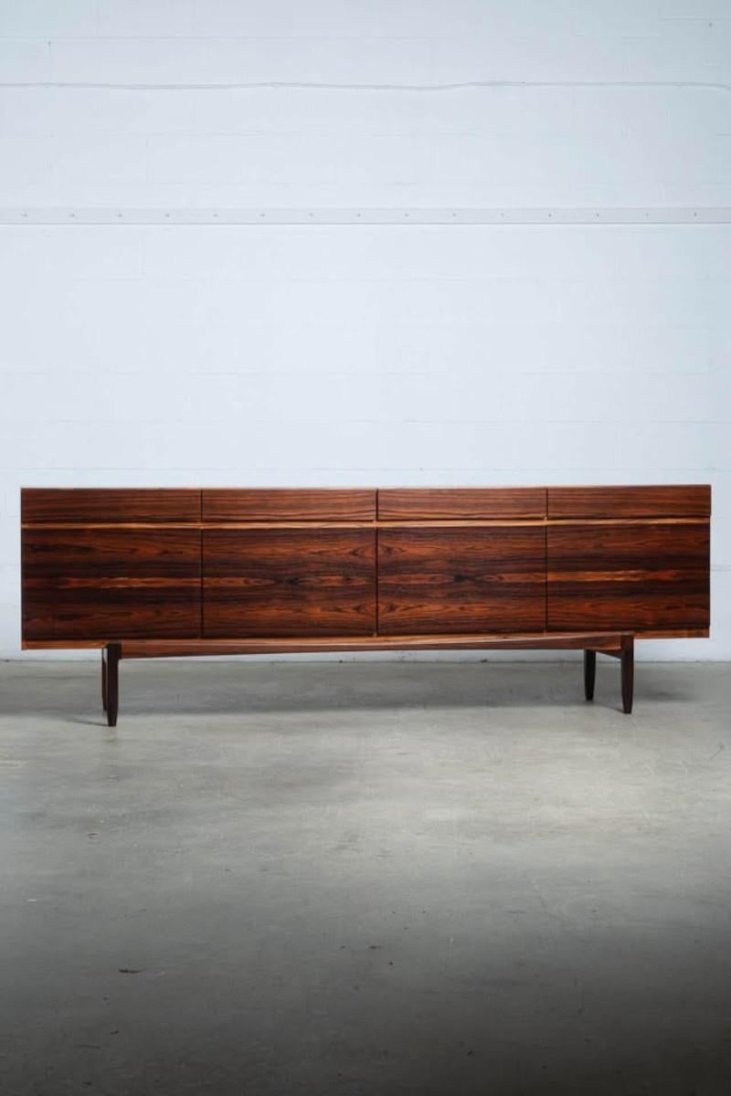 Un exemple exceptionnel de première génération de l'emblématique buffet FA-66 conçu par Ib Kofod-Larsen pour Faarup Møbelfabrik dans les années 1950. Fabriqué en palissandre brésilien richement figuré, ce meuble présente des veines étonnamment