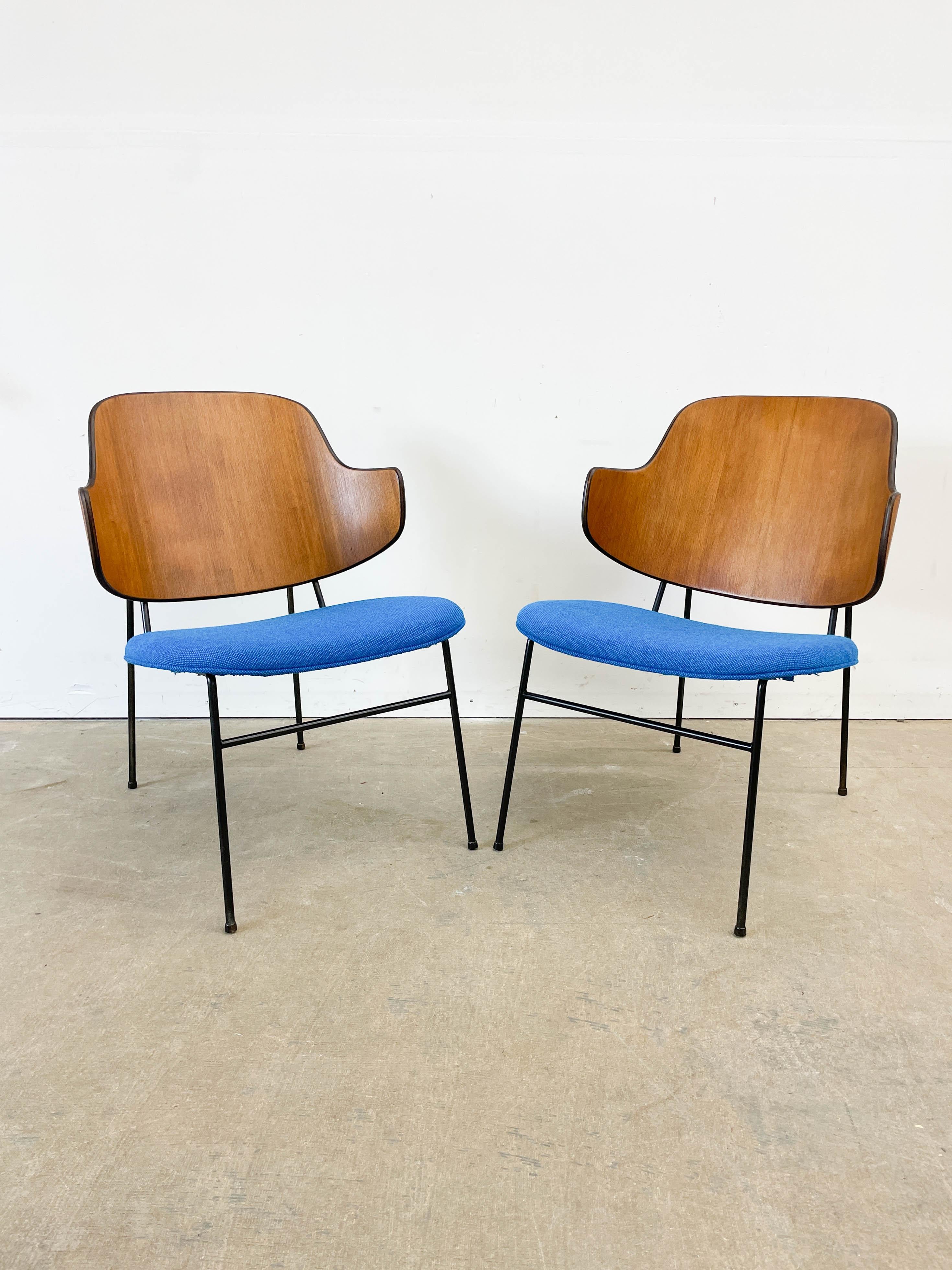 Pair of iconic Penguin Lounge chairs designed by Kofod Larsen and distributed by Selig in the early 1950s. The distinctive bent plwood back with teak veneer earned this chair the Penguin moniker when it first debuted in the USA around 1952. Paired