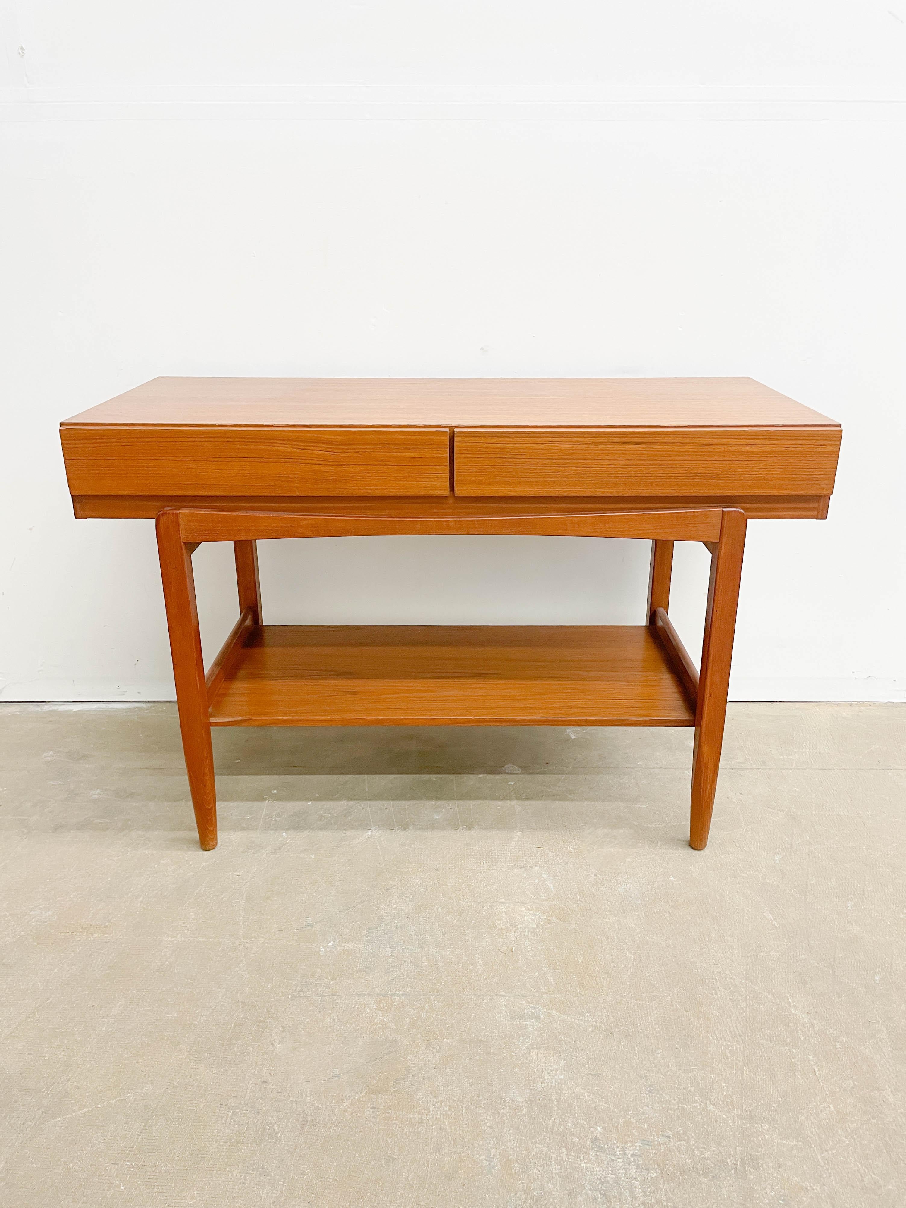 Elegant and practical, this console height table was designed by Ib Kofod Larsen for Faarup Mobelfabrik in the 1960s. Featuring an ample top surface, two large drawers and a lower shelf, it offers excellent storage options for an entry hall, bedroom