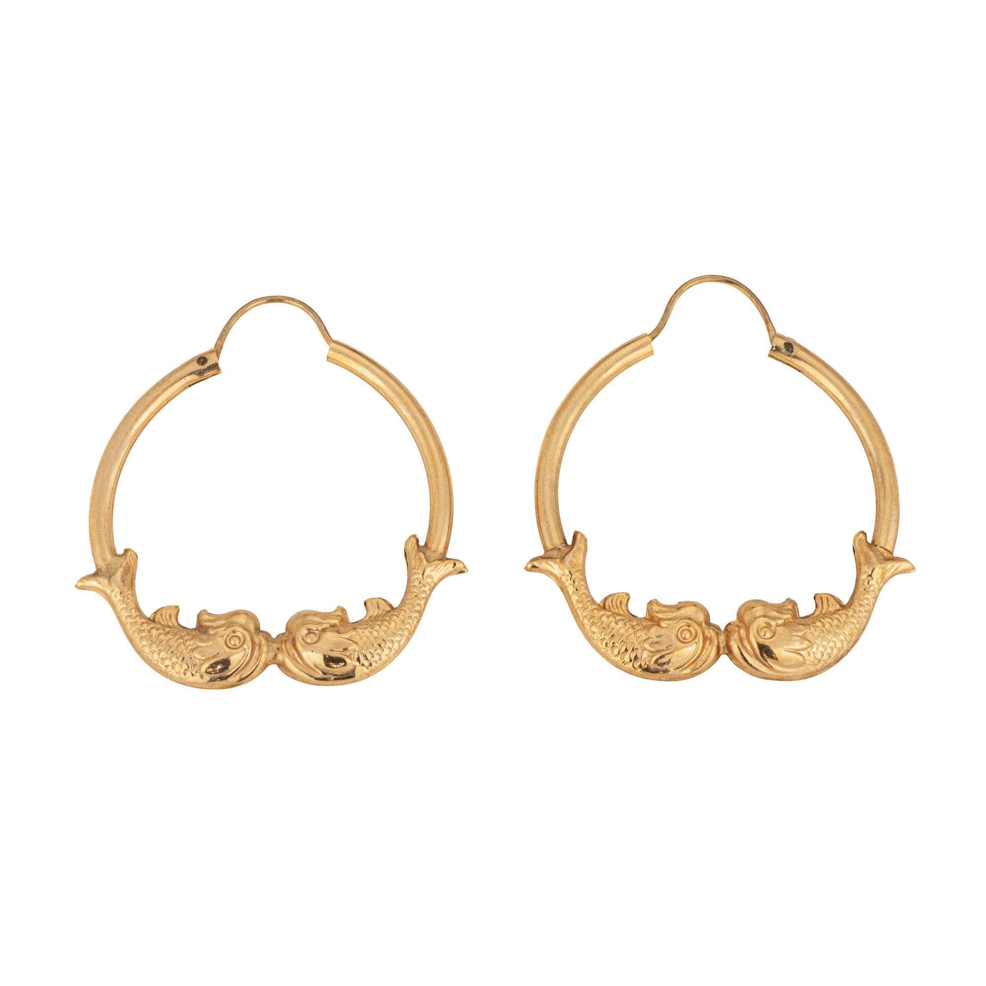 Fine detailed pair of oval koi fish hoop earrings crafted in 14k yellow gold. 

The stylish earrings feature two koi fish joining together at the base of the earrings. The koi fish is a symbol of good fortune, love, and friendship. The hollow