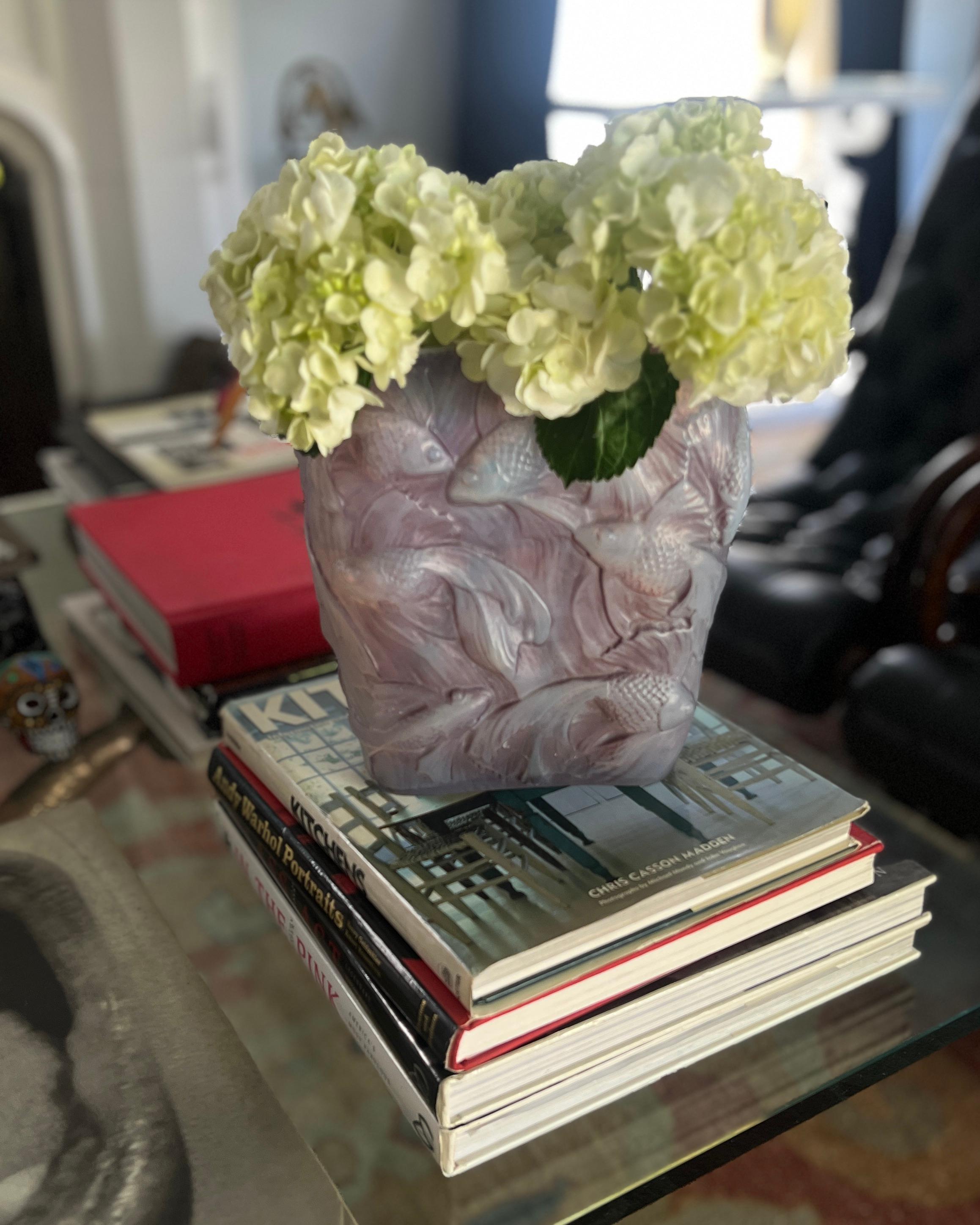 Un bellissimo vaso con Koi che nuotano nello stile di Lalique.

Il vetro opalescente color lavanda con i pesci tridimensionali è un'immagine meravigliosa.   Il vaso può stare da solo come pezzo decorativo, ma con l'aggiunta di fiori si trasforma in