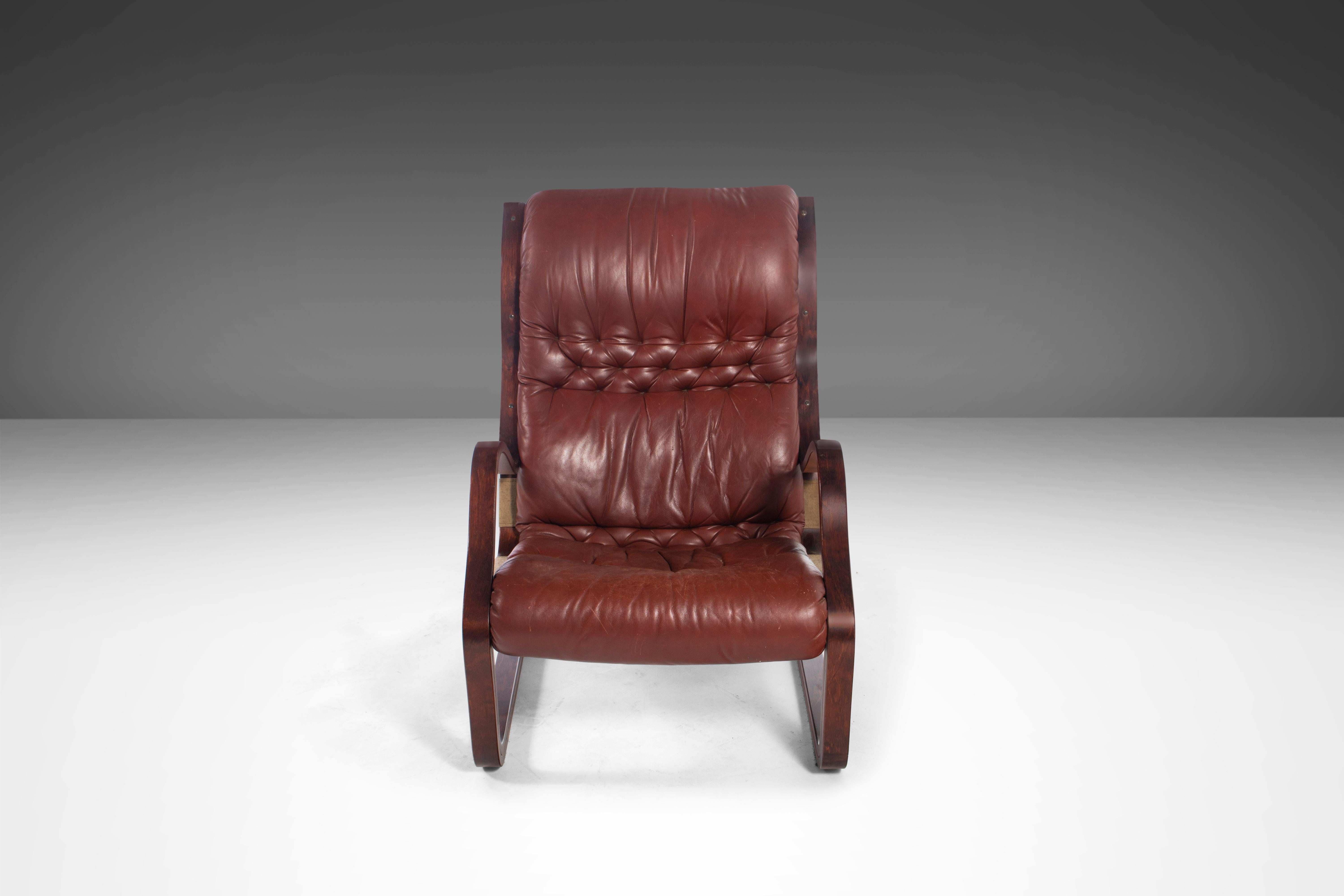 This absolutely exquisite 'Koivutaru' armchair with matching ottoman from the 70's in the rare combination of afromosia and oxblood red leather was ahead of it's time. Designed by the visionary Finnish designer Esko Pajamies for Asko in 1977, this