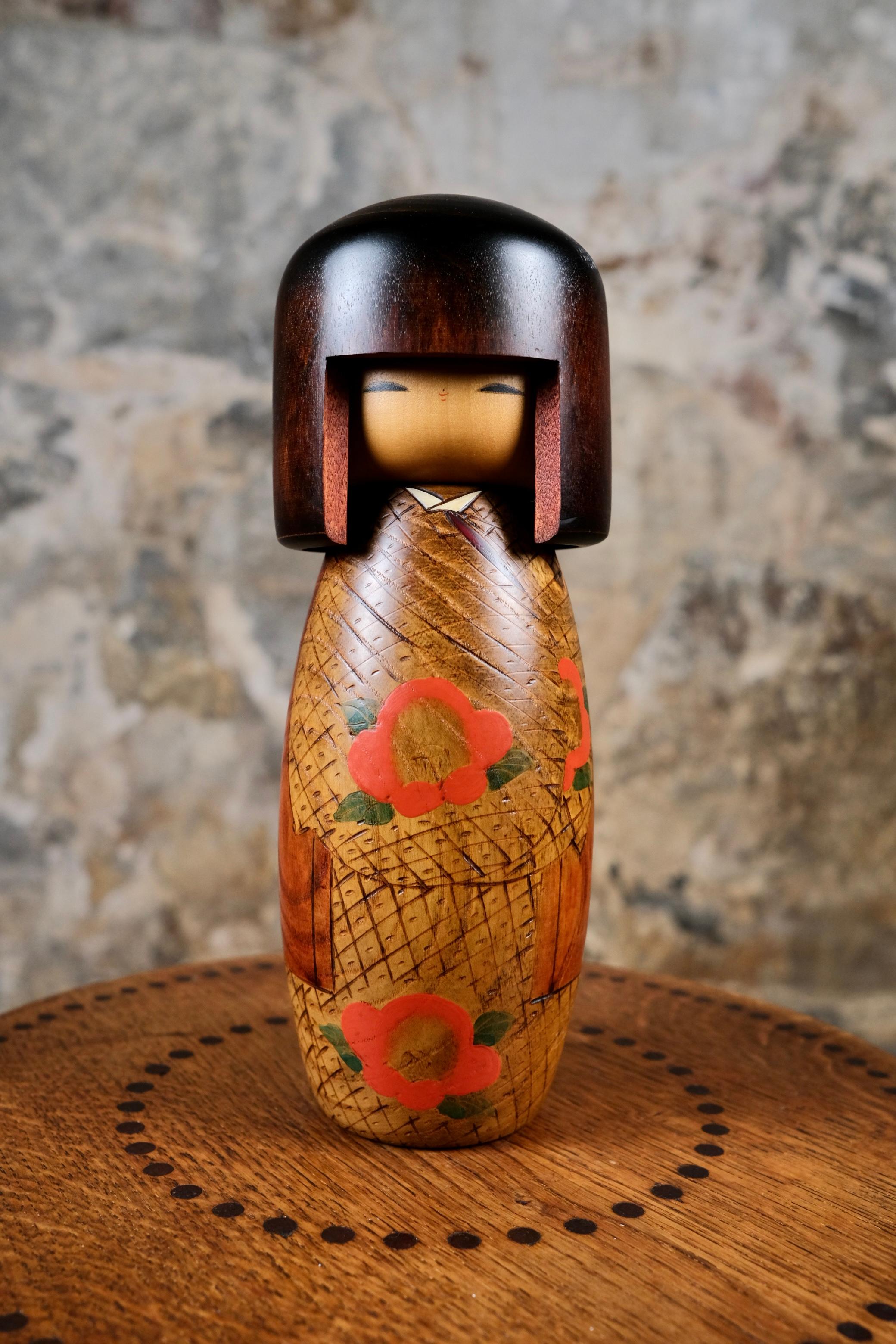 Kokeshi con camelie, realizzata nel 1990 da Usaburo.
Elegante kokeshi con kimono ornato di camelie. La camelia è un fiore invernale.
In ottime condizioni, con il suo adesivo.

La kokeshi in poche parole?
Realizzate a mano in Giappone, queste bambole