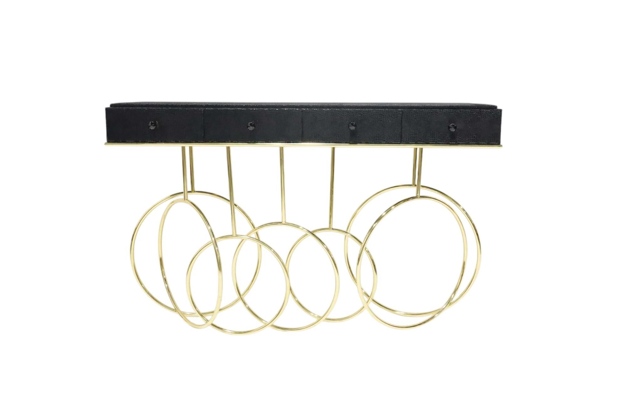 Revisit the dazzling world of a French cabaret through the Burlesque console. The acrobatic brass  loops & spins of the base paired with black exotic leather skins and a black crystal on each one of the 4 drawers exude the mysterious traits of a