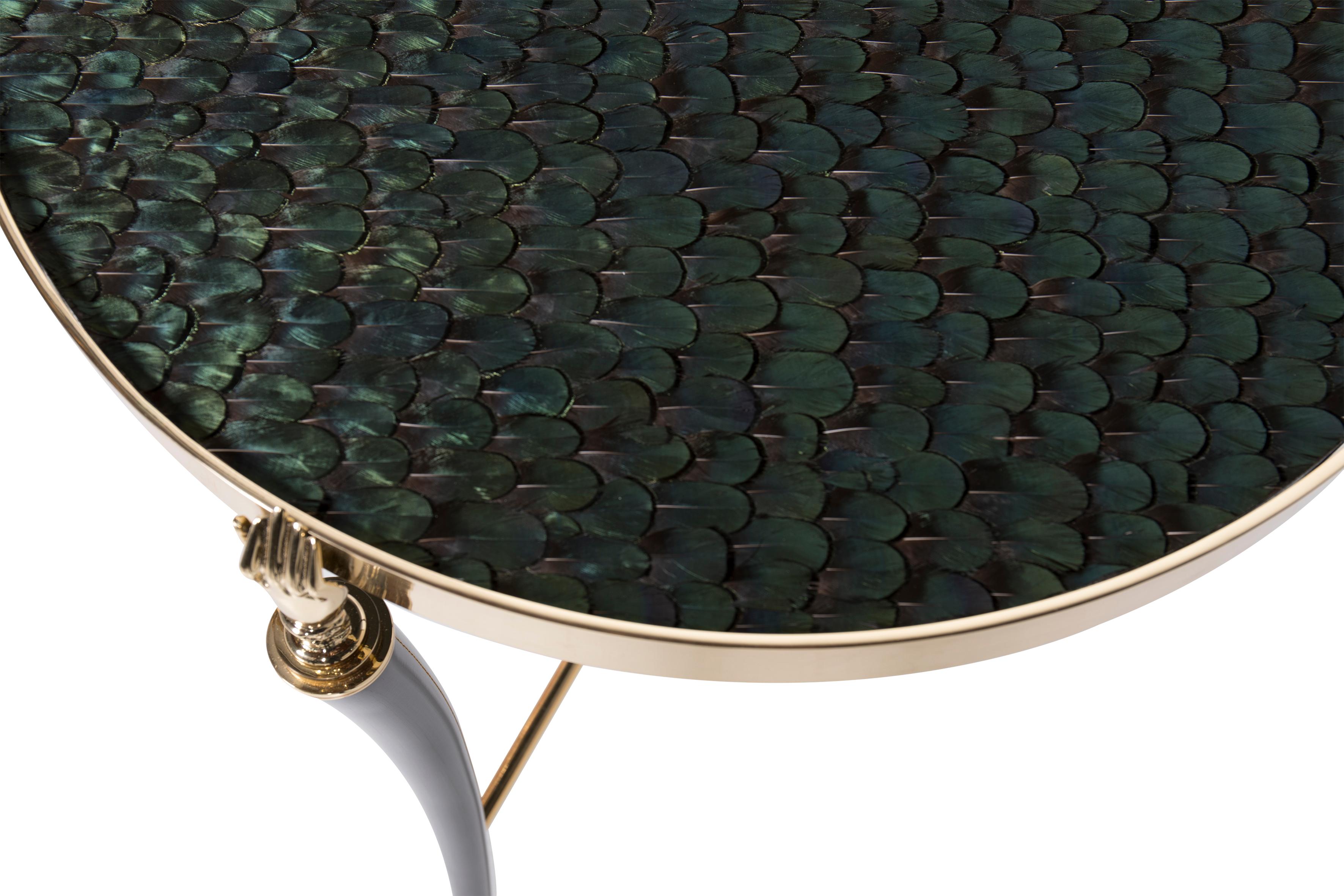 Three elegant Victorian cast brass hands on a delicate tripod base hold iridescent peacock feather top. This luxurious table is sure to be a showstopper in any room.

Legs: Black lacquer with high gloss finish 
Top: Covered in iridescent peacock