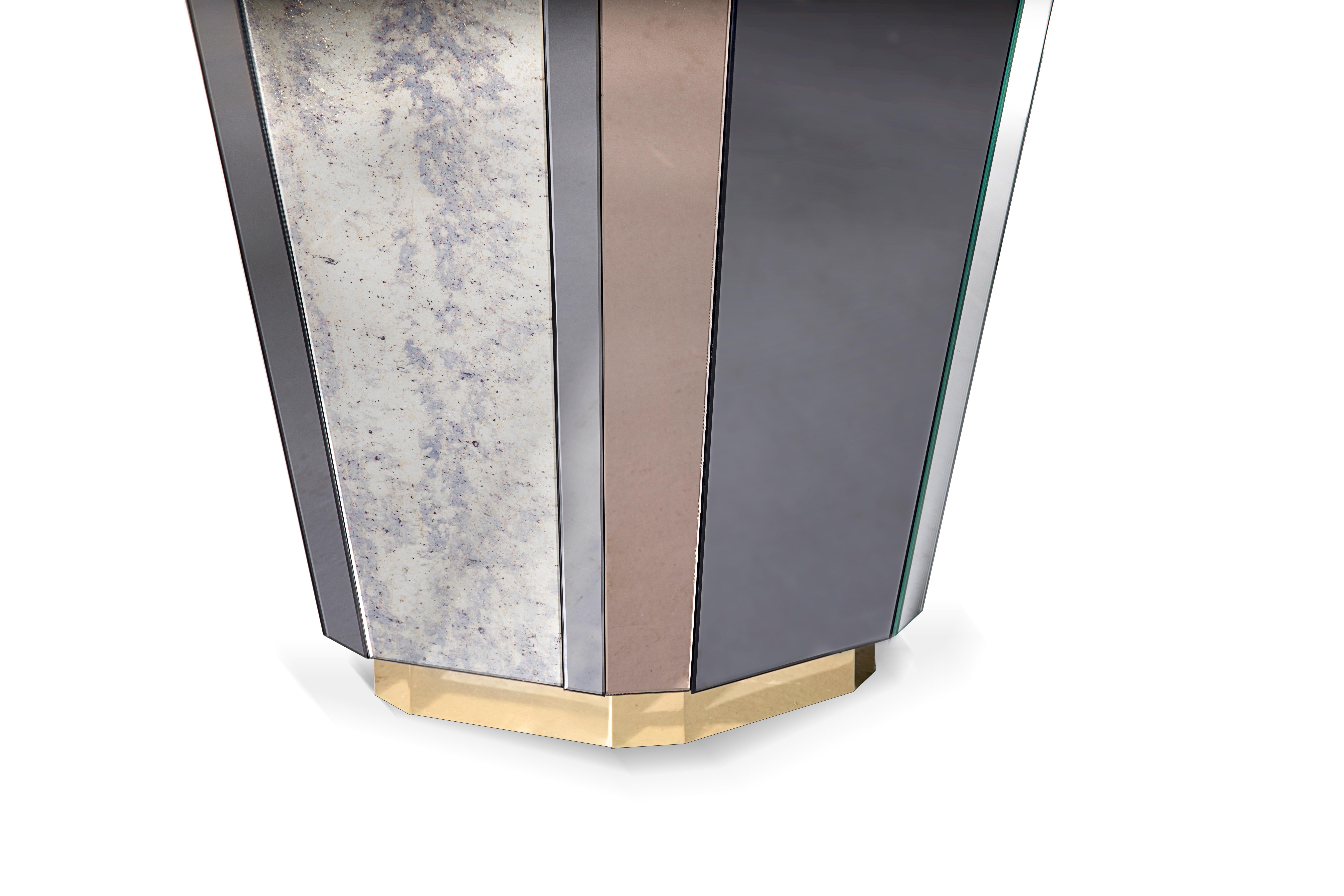 The Lemprica side table brings together the whirlwind decade of the 1920s with rich angular shapes and multicolored glass from the Art Deco period.

Base: Polished brass with high gloss finish 
Structure: Antique, clear, bronze and smoked mirror