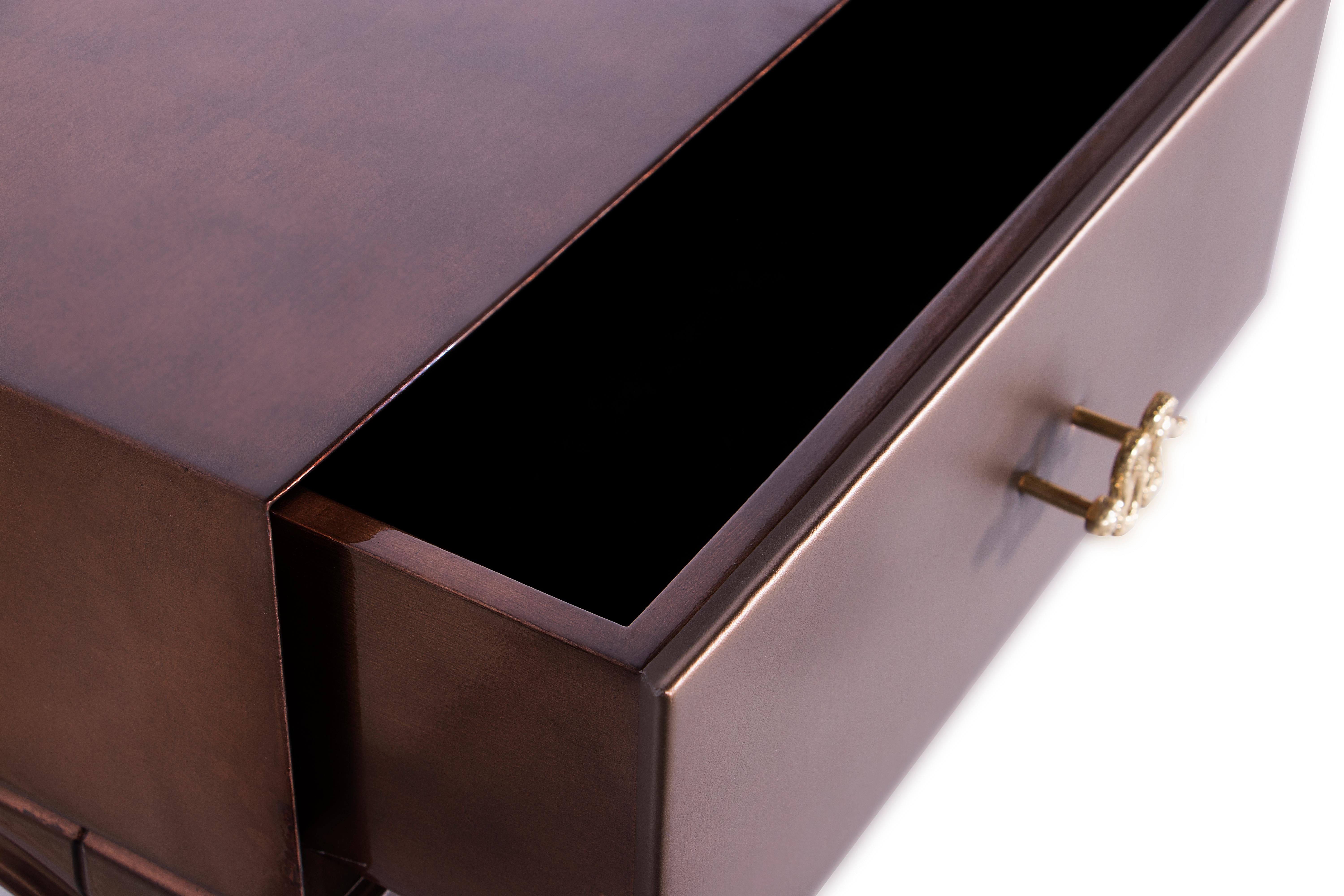 Fierce details packed with primal power, verve and bite wrap this reptilian console. Drawer fronts composed of various materials, finely refined by brass coiled snake hardware.

Top: Iridescent caramel with high gloss finish 
Base: Iridescent