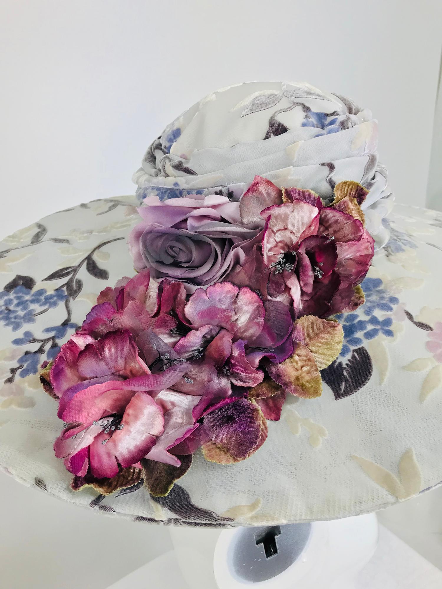 Kokin floral embellished devore velvet wide brim hat from the1990s. This beautiful hat is perfect for any occasion that requires you to look amazing. Oval brim hat is covered with pale grey devore velvet the design is floral with branches and