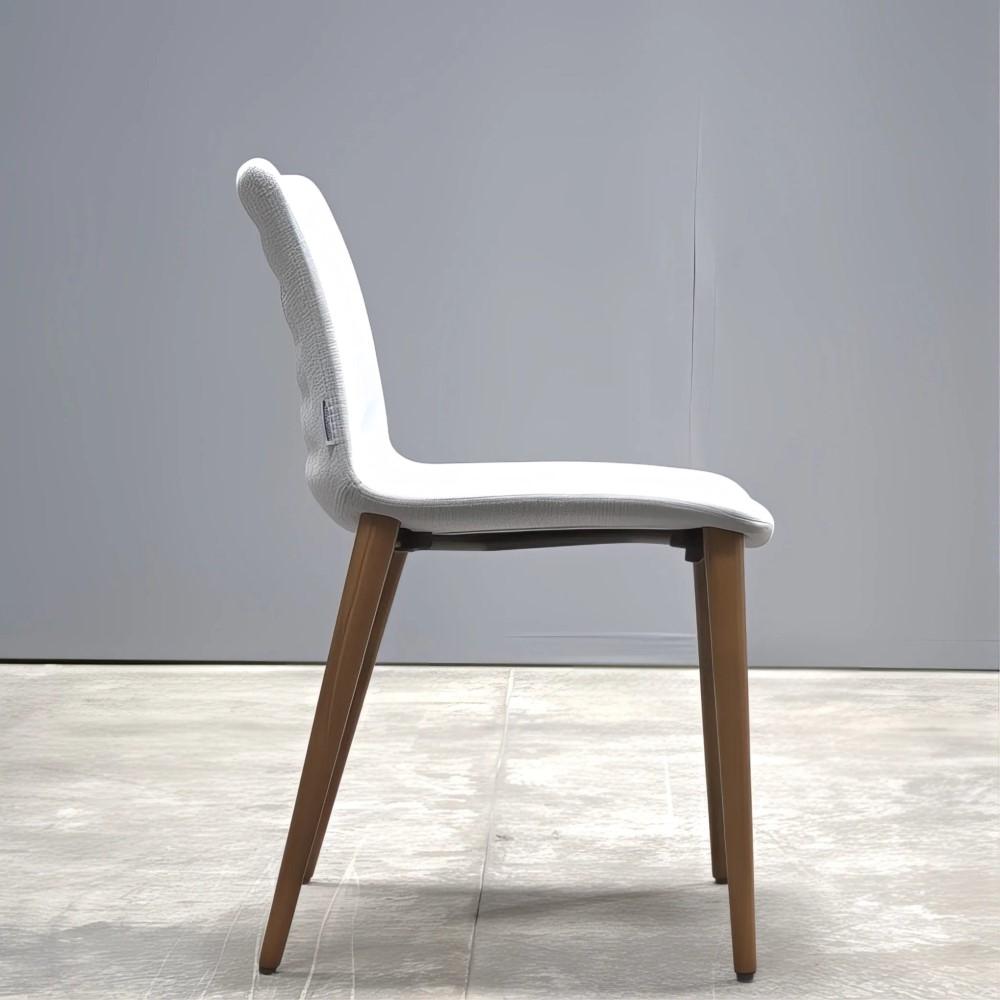 The Koleksiyon Helen S0 SH10 Chair by Tasarımcı Studio Kairos epitomizes timeless elegance with a modern twist. This refined piece is a testament to meticulous craftsmanship, featuring a beautifully contoured seat enveloped in premium fabric. The