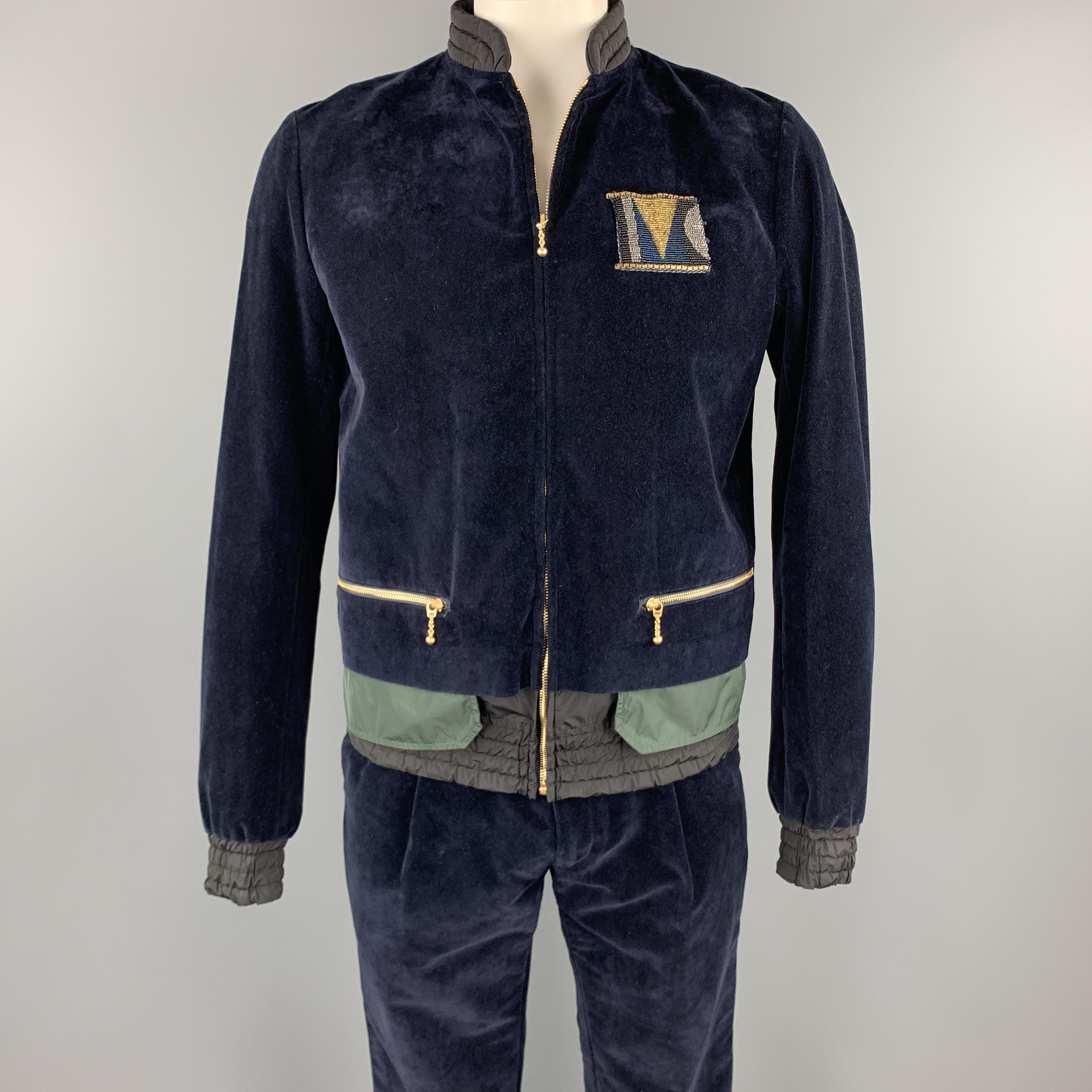 KOLOR track suit comes in a navy velvet with mixed material details featuring a front beaded detail, quilted collar, front pockets, zip up closure and matching jogger pants. Made in Japan.

New With Tags.
Marked: 4
Original Retail Price: