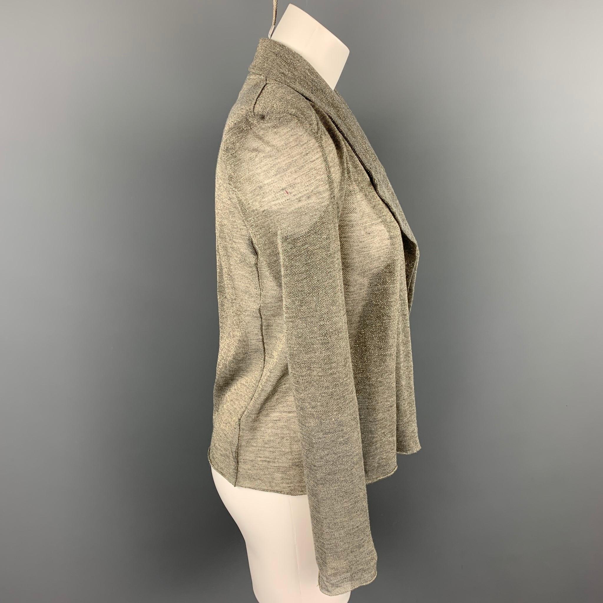 KOLOR jacket comes in a silver & grey metallic polyester featuring a peak lapel, shoulder pads, and a open front style. Made in Japan.

Very Good Pre-Owned Condition.
Marked: JP 1

Measurements:

Shoulder: 15 in.
Bust: 37 in.
Sleeve: 26 in.
Length: