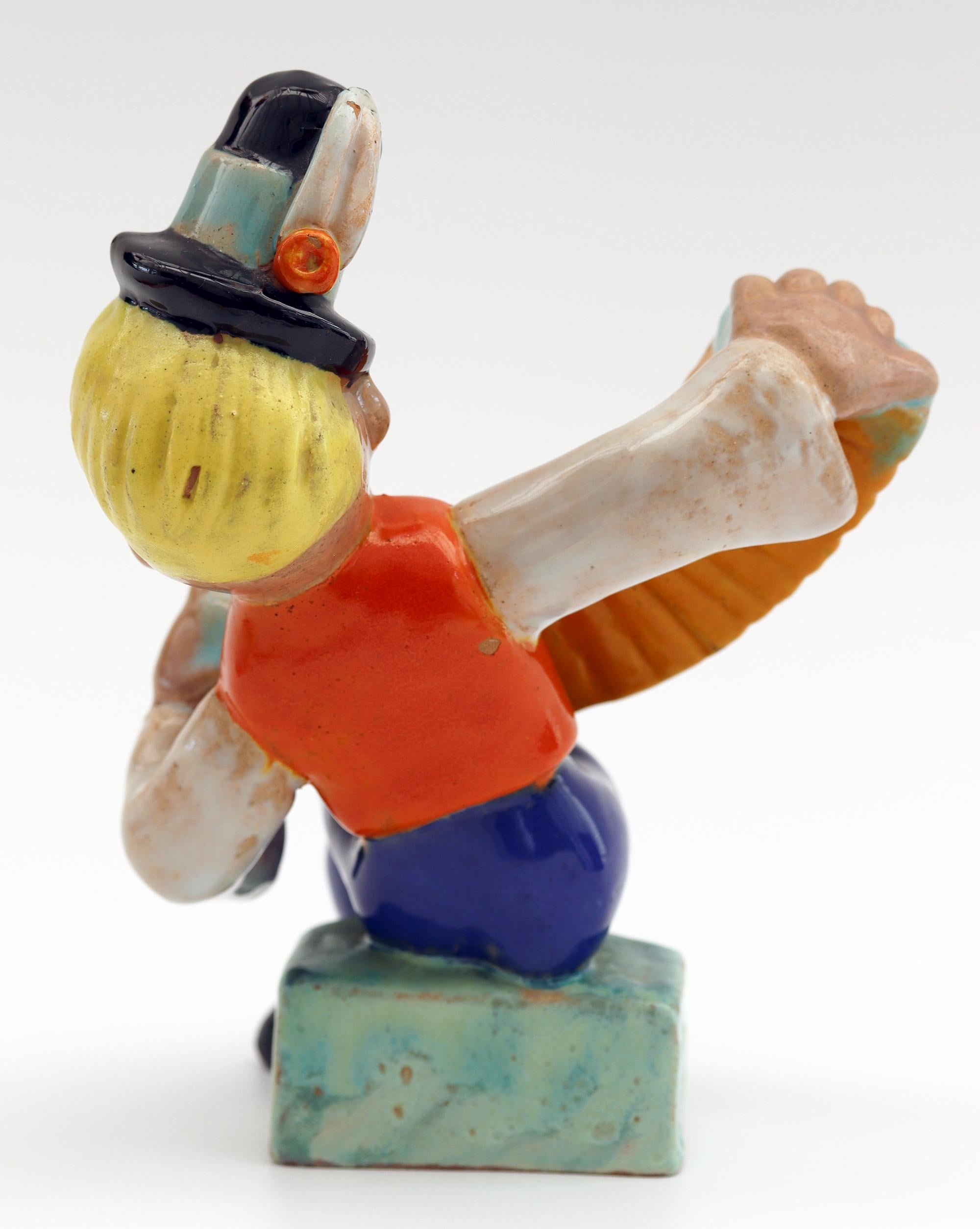 A charming Art Deco Hungarian hand painted pottery figure of a musician by Komlos and dating from circa 1930. Reminiscent and probably inspired by the Wiener Werkstatte and Goldscheider in nearby Austria, the figure portrays a young seated boy