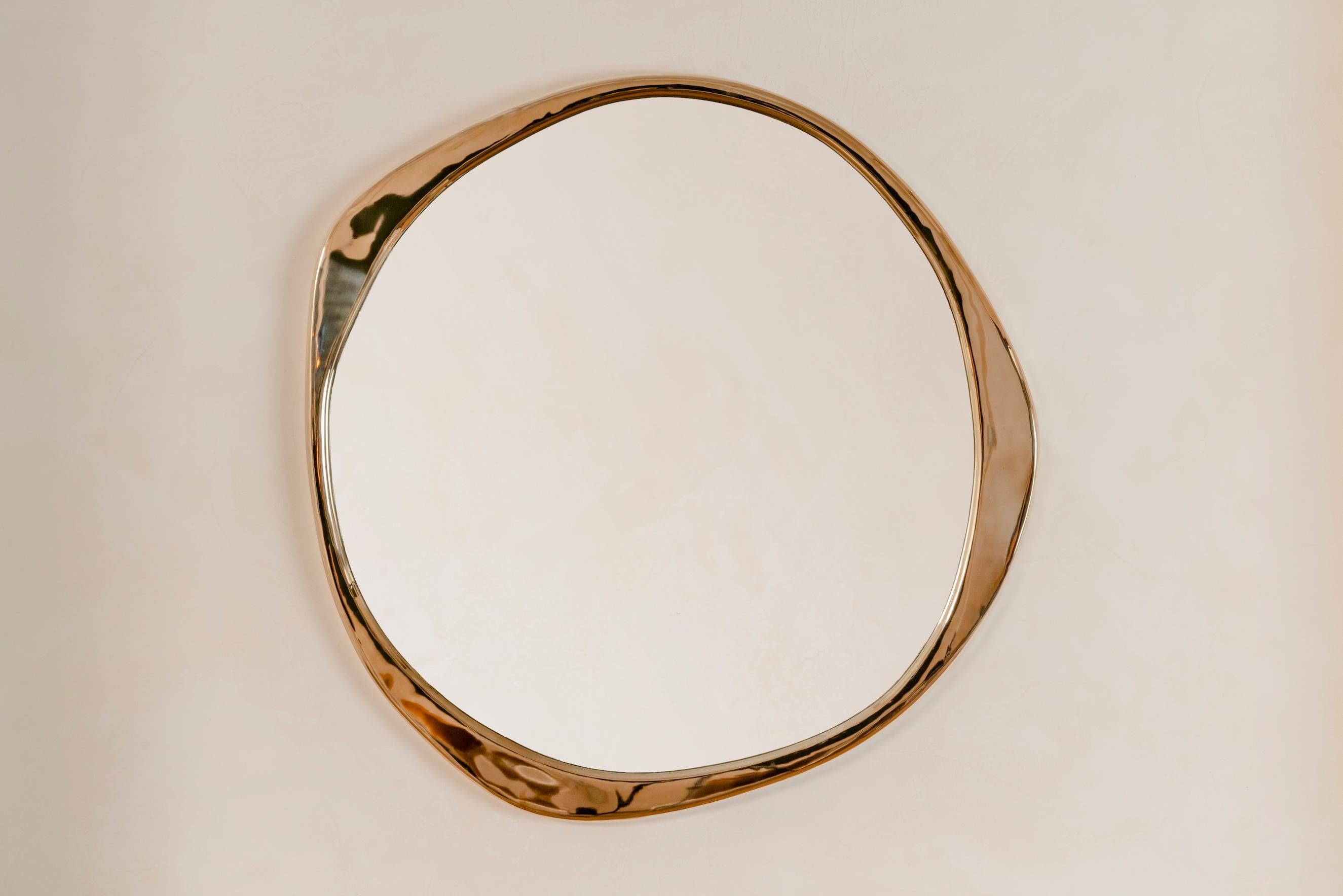 Le sculptural miroir A.Cepa en bronze poli est coulé en bronze dans une fonderie d'art en Pennsylvanie, et habilement poli à la main. De forme ondulée et irrégulière, le miroir A. Cepa est le point de mire de toute pièce grâce à sa forme organique