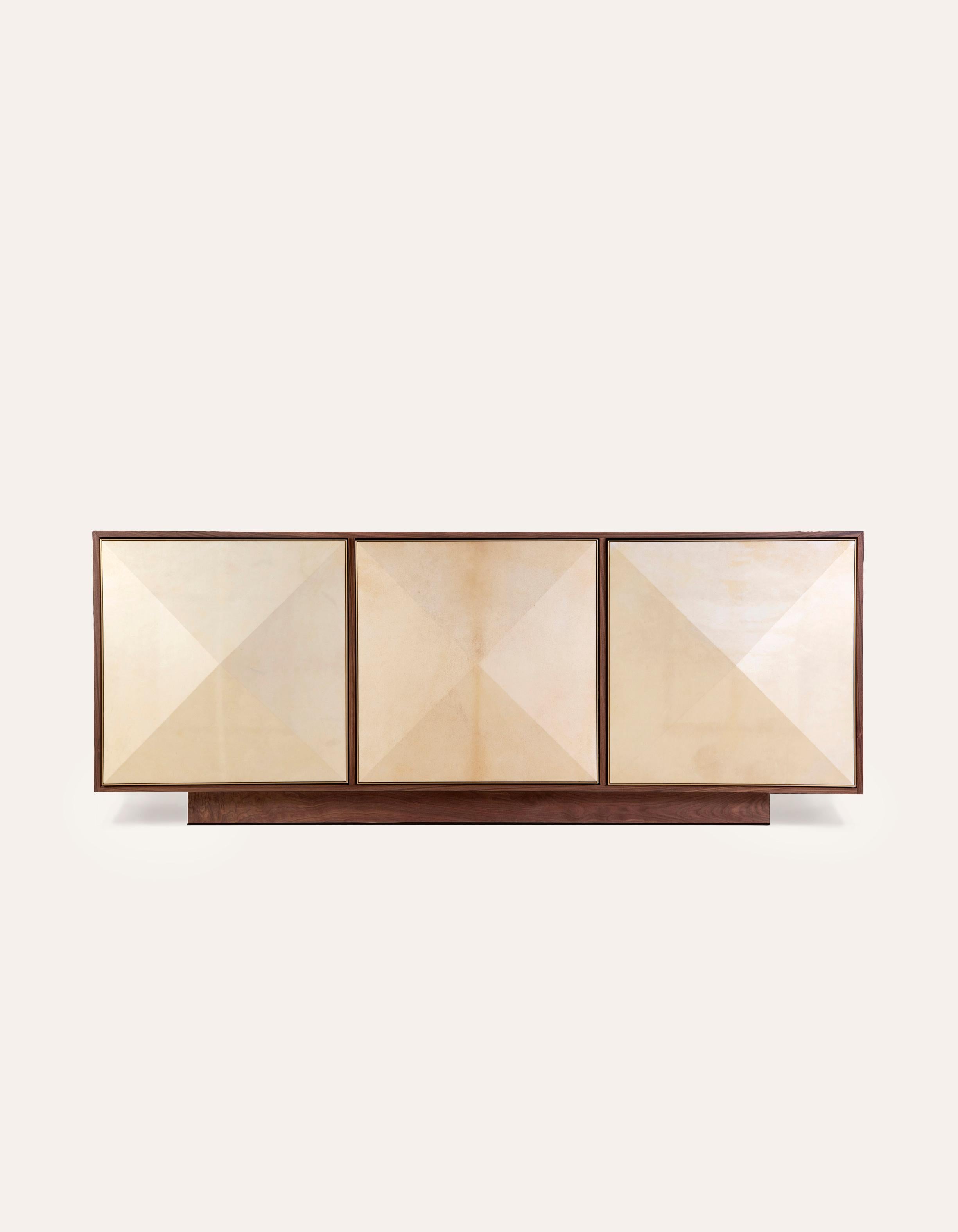 The Pyramid Sideboard features three-dimensional doors hand-wrapped in natural goatskin parchment and framed subtly in satin brass.

This listing is for the 3-Door Large sideboard in Natural Walnut. Please inquire for other wood finish and size