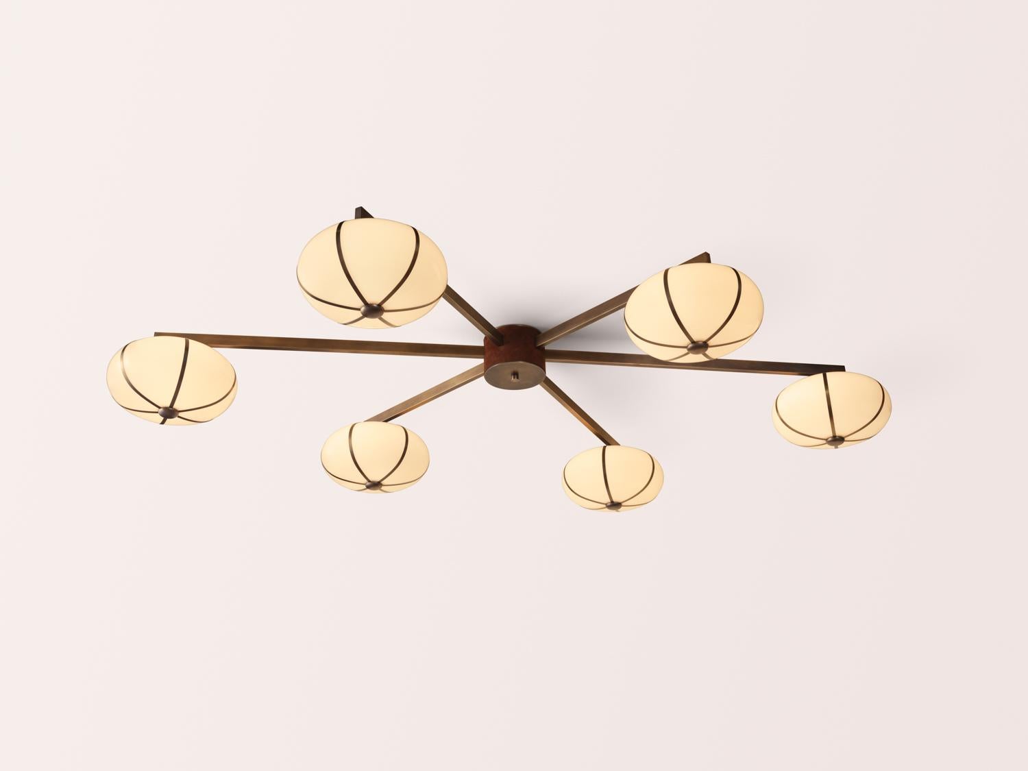 The Rib Chandelier 6 Flush Mount is anchored by a cylindrical core, hand-wrapped in leather or suede. Six glass pendants, framed by slender brass ribs, extend outward to form a balanced constellation of texture, structure, and light. 

Available in