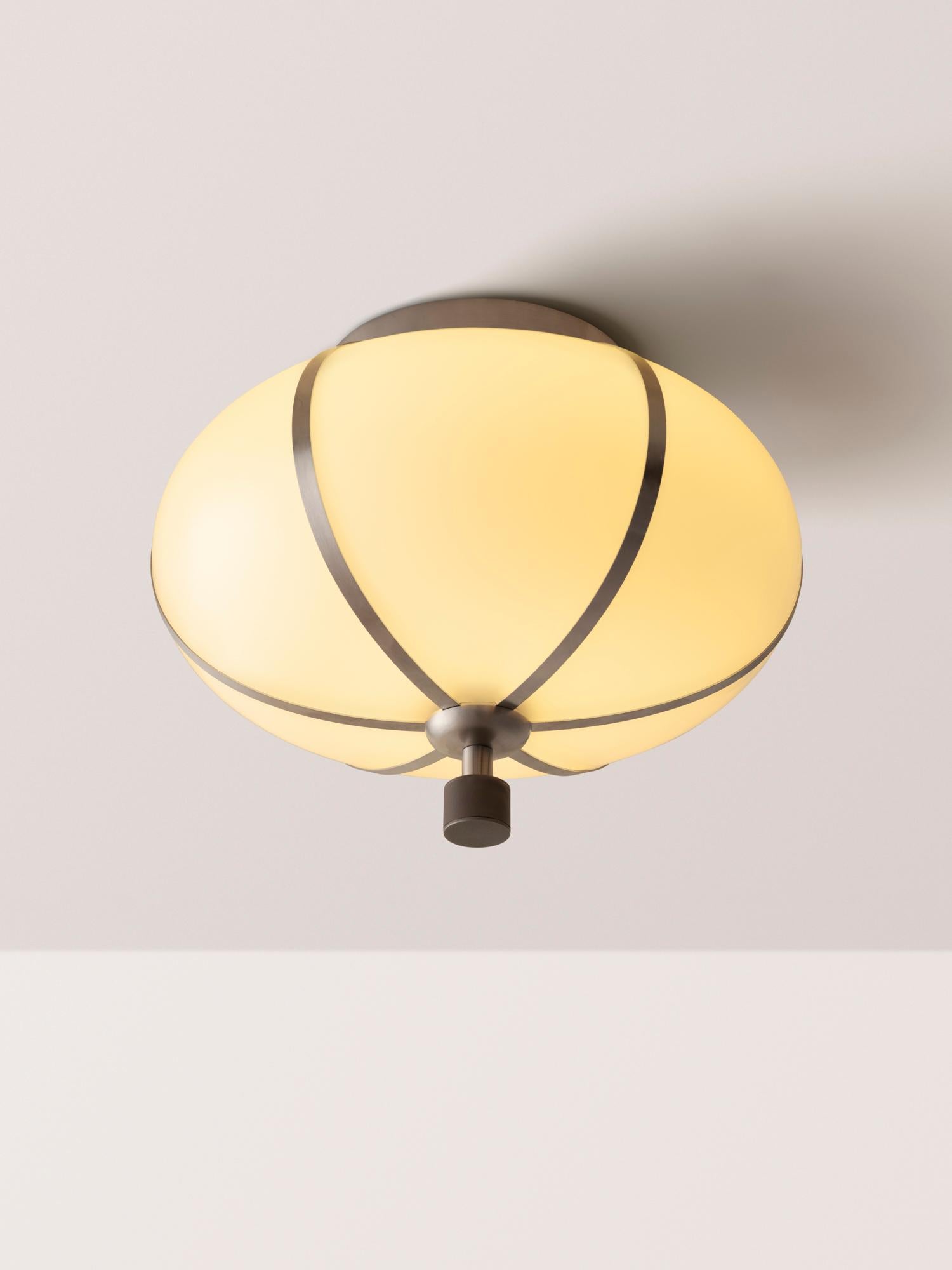 The Rib Flush Mount - Small Ellipse is blown in Italy and delicately framed by thin brass ribs. A cylindrical brass finial, with optional hand-wrapped leather or suede, elongates the fixture and adds a finishing touch of refinement.

Available in a