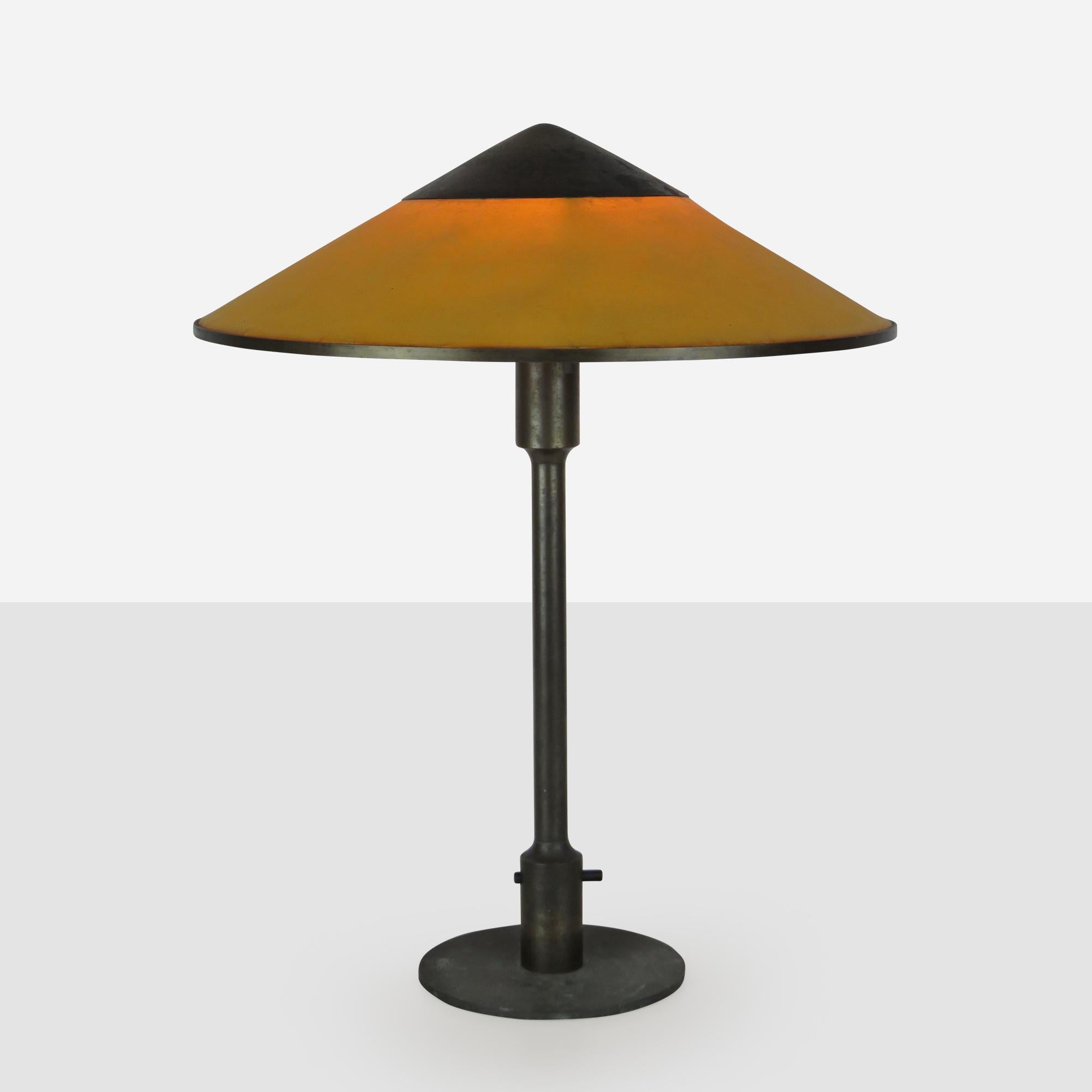 An early Kongelys table lamp by Niels Rasmussen Thykier for Fog and Mørup. The fixture is made of brass and copper with a continuous switch and an oil-treated paper shade in a warm yellow. New wiring and plug.