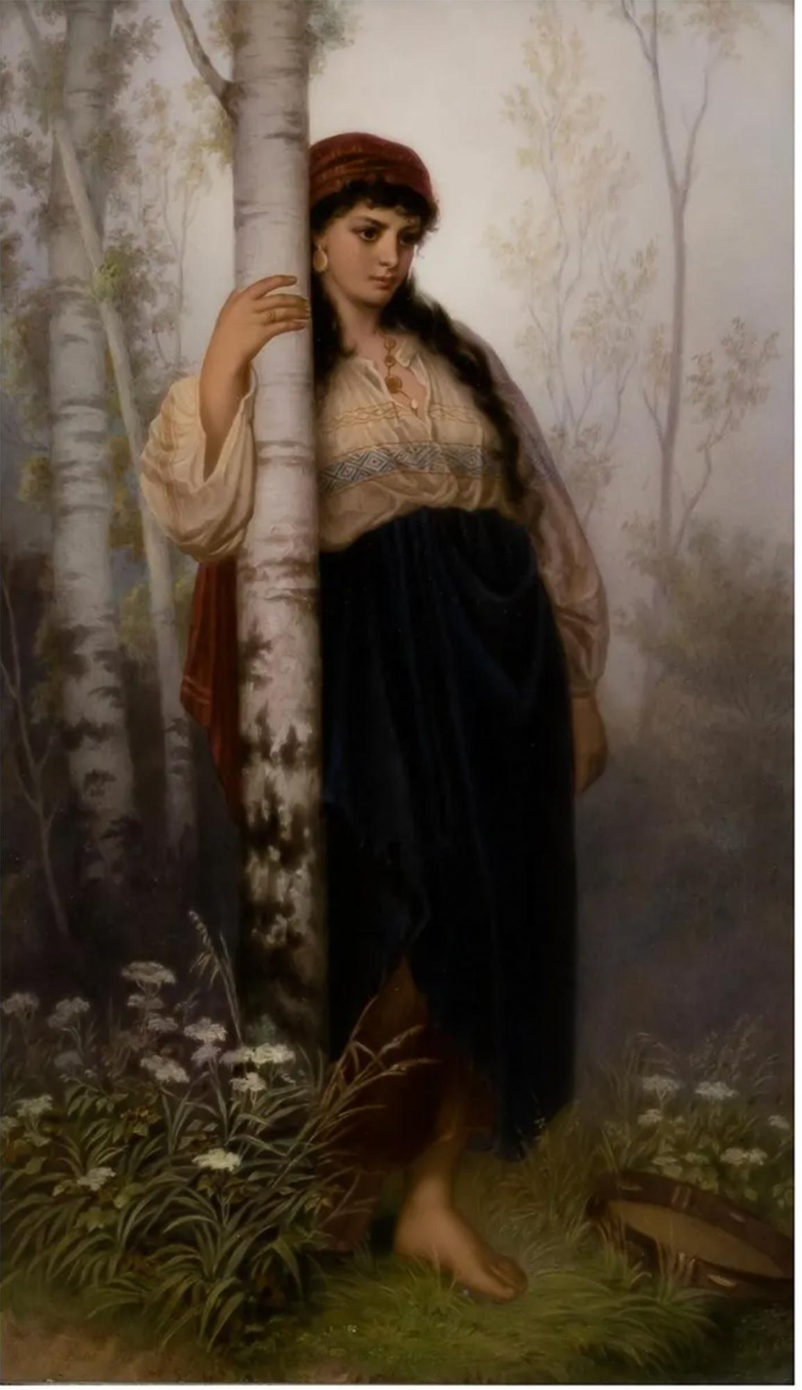 A delightful porcelain plaque of a middle eastern woman wearing a head scarf, gold medallion jewelry and an embroidered shirt with puffed sleeves. A tambourine sits on the ground before her as she leans against a birch tree, casting her powerful