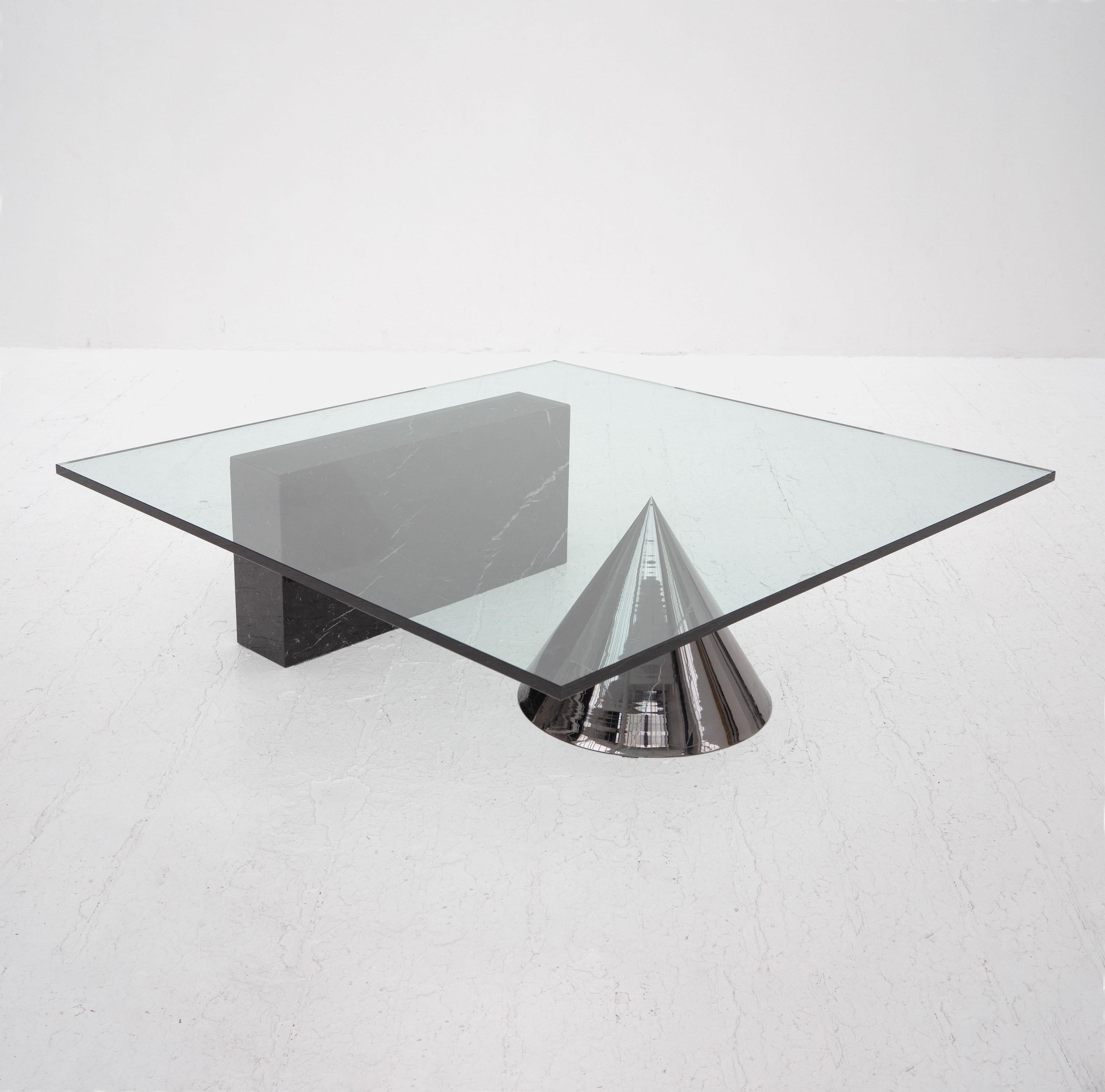 A Kono coffee table designed by Lella & Massimo Vignelli and produced by Casigliani, c.1980. Composed of a solid black marble cuboid and tinted chrome steel cone supporting a thick toughened glass top.

For over 50 years, Italian-born