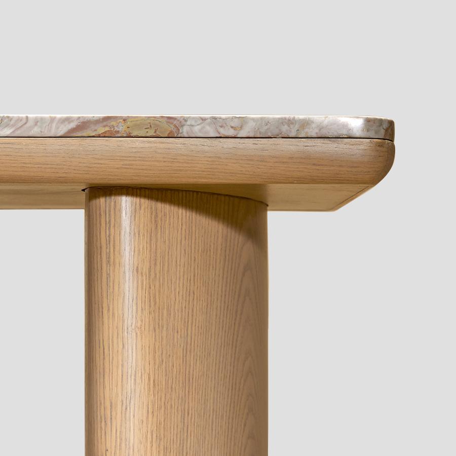 Konsole es una pieza que juega con el equilibrio visual mediante la combinación de materiales y formas contrastados. El mármol Arabescato Rosso, con su veteado audaz y orgánico, aporta una presencia vibrante que llama la atención y confiere a la