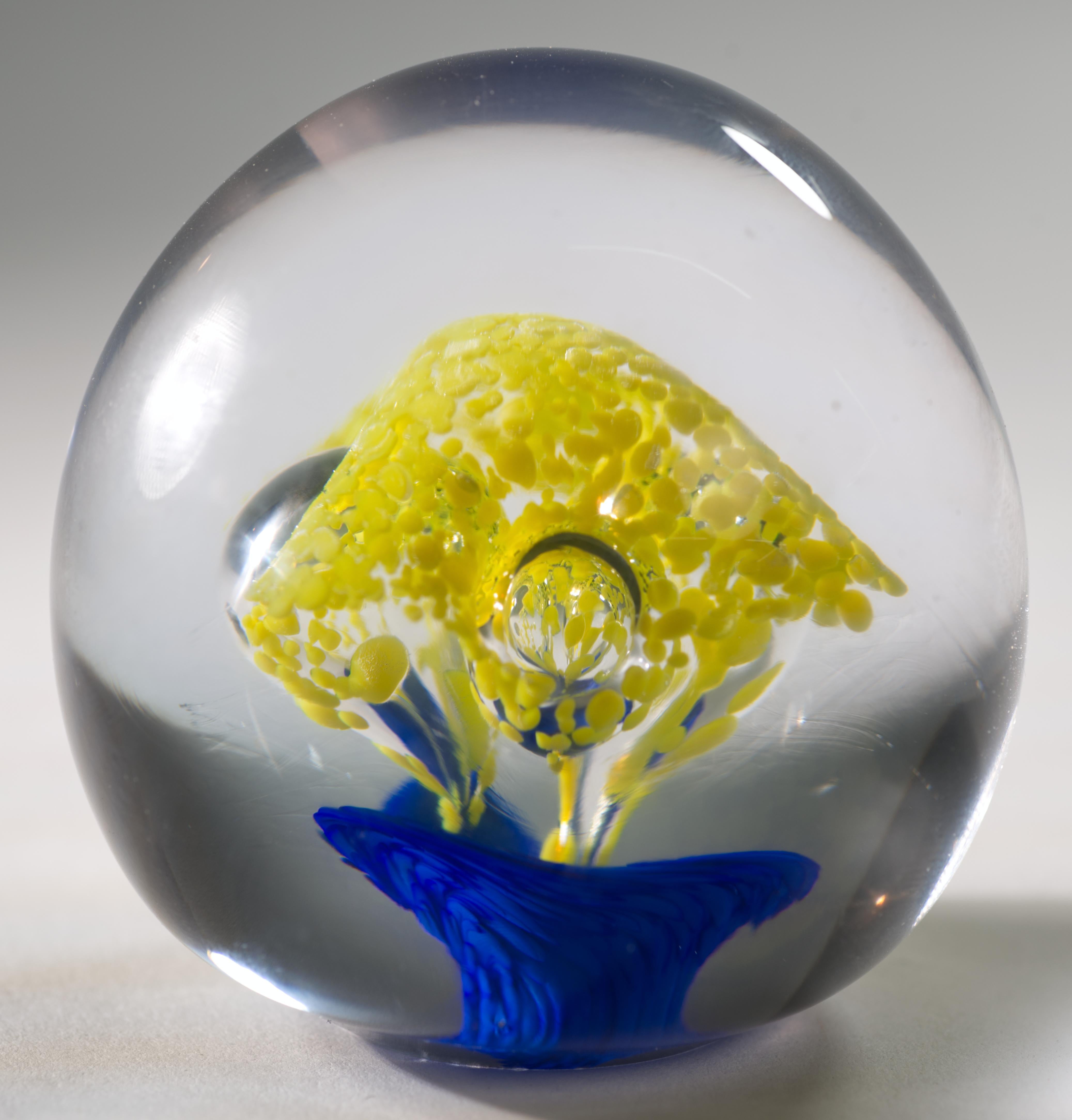  Le presse-papier sphérique Vintage présente un noyau central lumineux et graphique en verre bleu et jaune avec 3 grandes bulles contrôlées, enveloppées dans du verre clair selon la technique sommerso. Le verre transparent brille à la lumière UV, ce