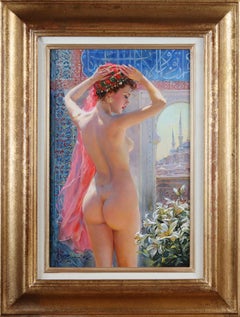 Hermosa odalisca de pie junto a una ventana