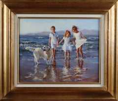 Niñas y un niño jugando en la playa con un labrador