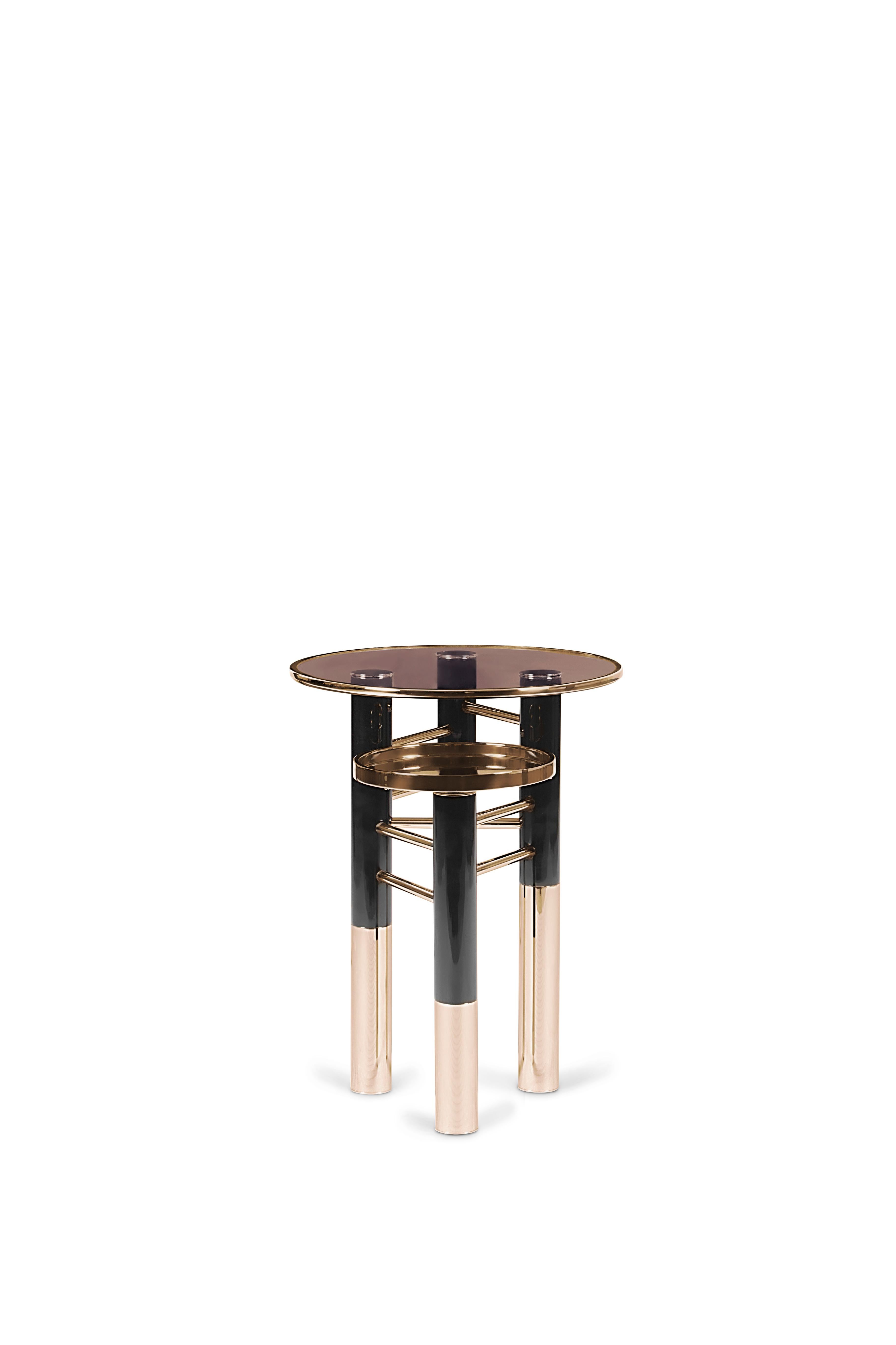Reduced shapes, clean lines and lots of black ‐ the Konstantin Side Table truly embodies what an Essential piece is, an elegant look full of refinement and modernity. This side table features a brown glass top with a gold trim and a gold plated tray