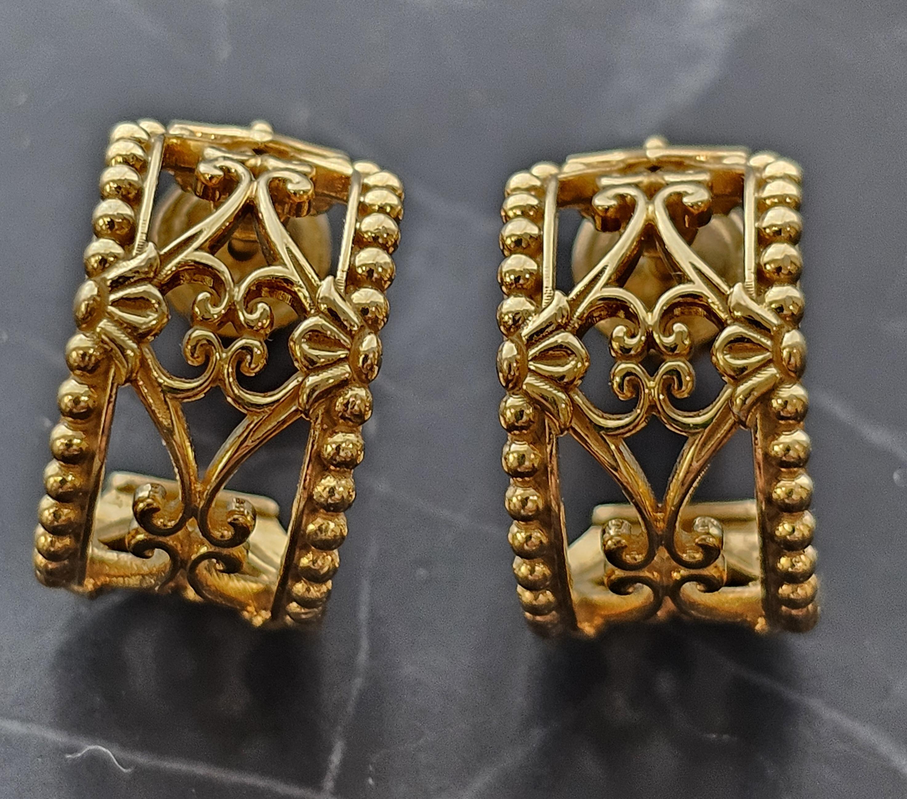Enhance your collection with these exquisite Konstantino hoop earrings. Crafted in 18k yellow gold, they showcase intricate Art Nouveau detailing. The design features ornate scrollwork and beaded edges, creating a captivating visual appeal.
