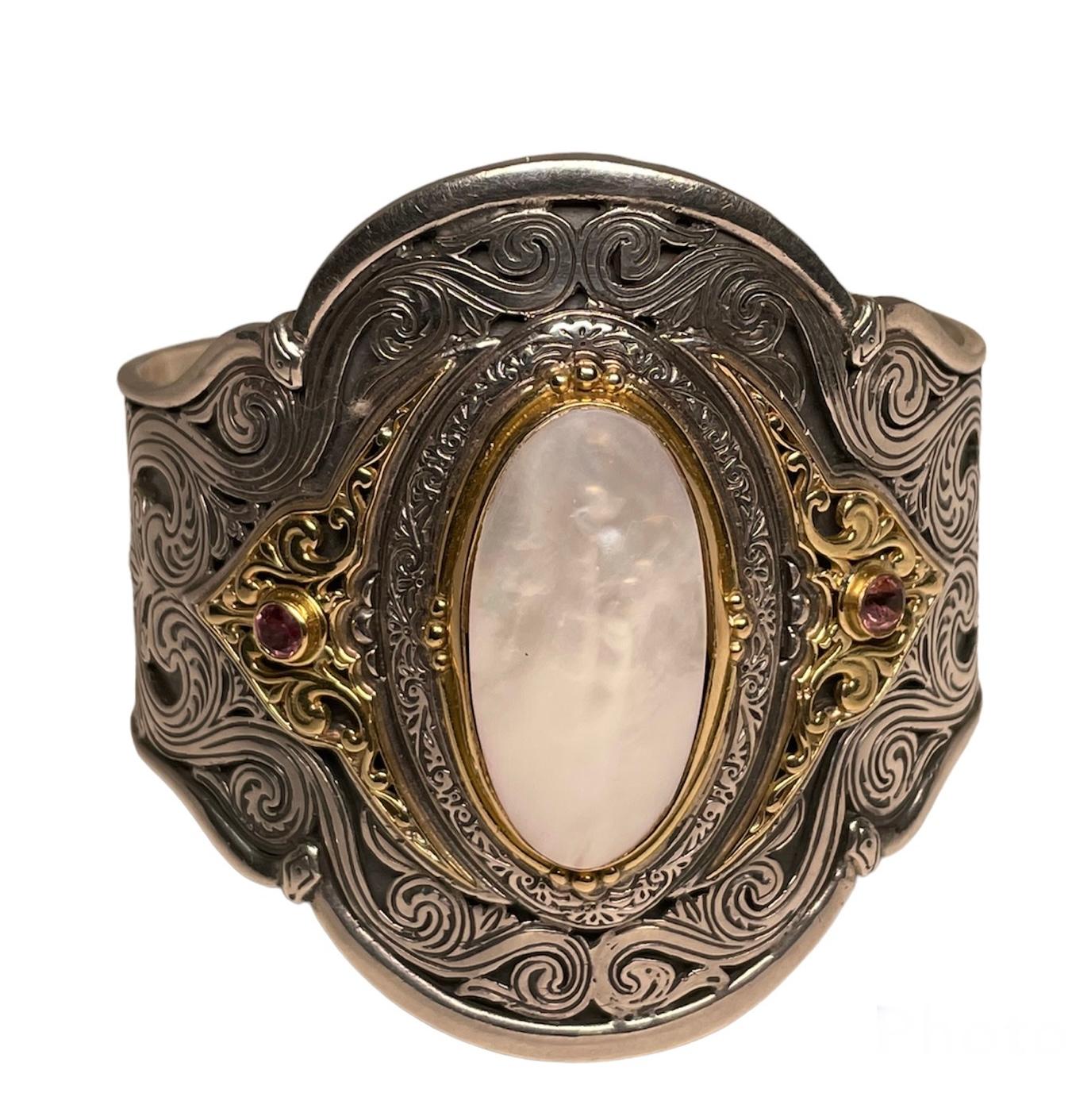 This is a Konstantino 18k yellow gold, sterling silver and mother of pearl cuff bracelet. It is adorned with a large oval cabochon mother of pearl in the center. This one is framed with gold and sterling silver. The sides of the framed oval are