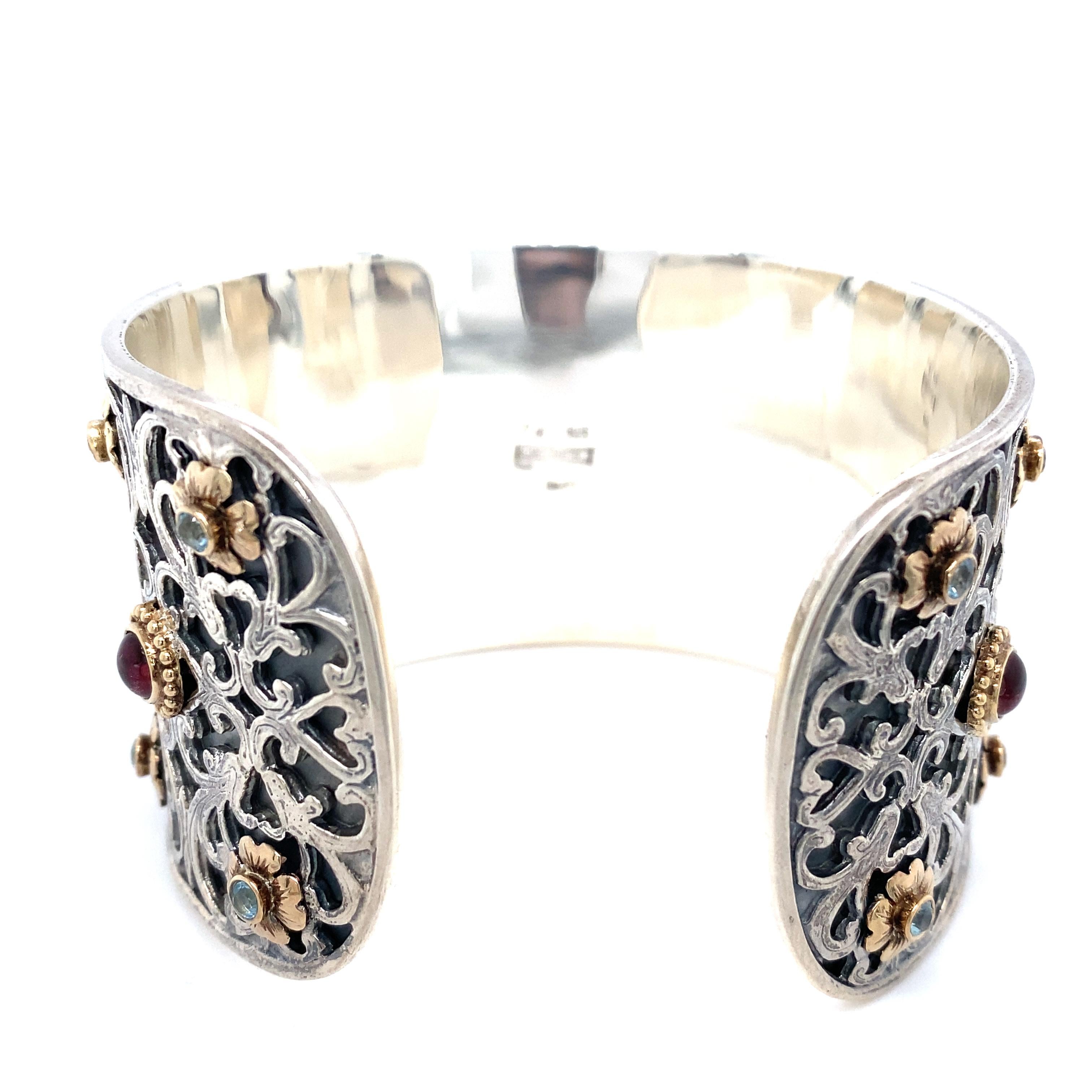 Item Details: This cuff bracelet by KONSTANTINO features cabochon amethyst and blue topaz stones in a silver filigree design. It has 18k gold accents around the stones. This sterling silver bracelet is signed with a maker's mark.

Circa: 2000s
Metal