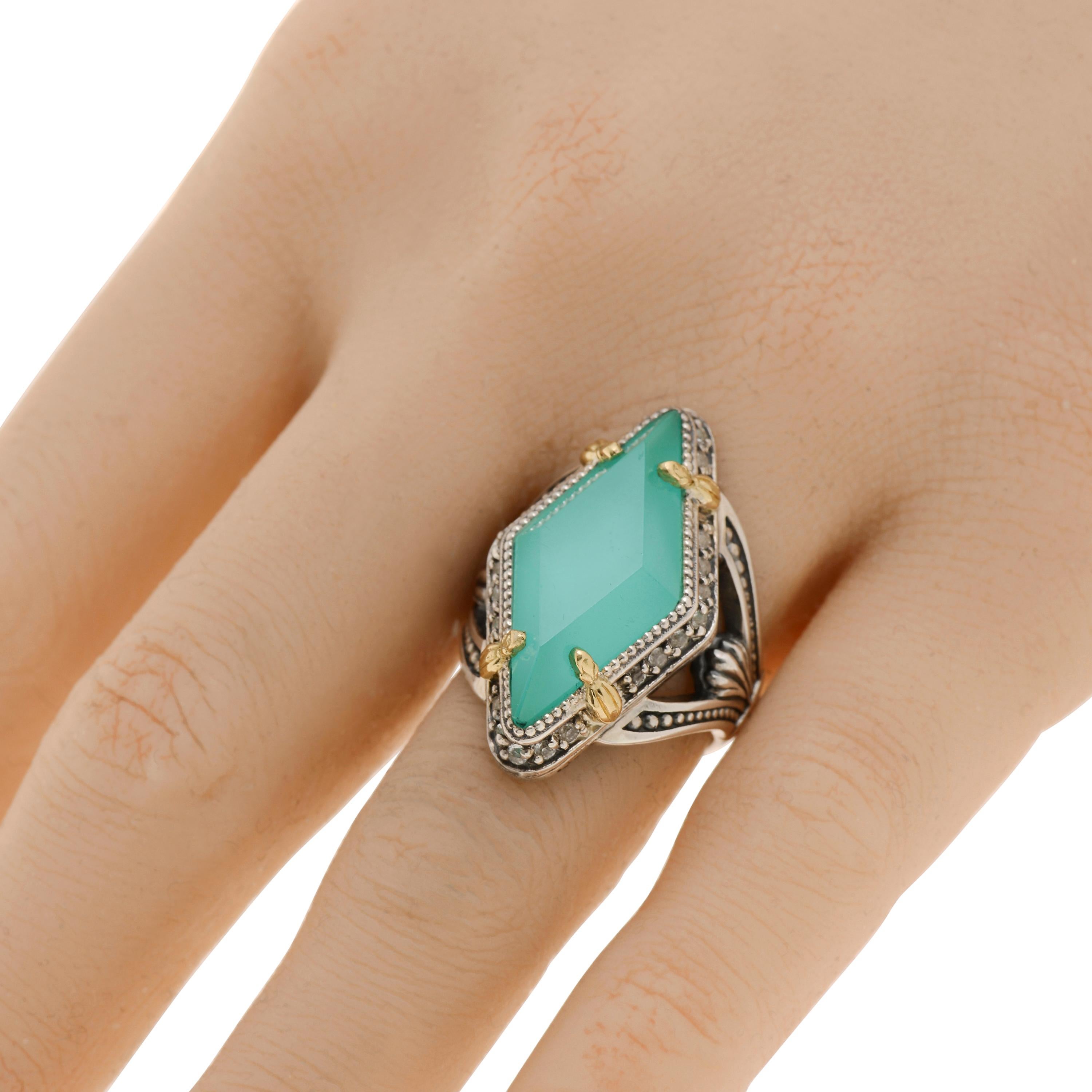 This eye-catching Konstantino ring features a teal chalcedony doublet white topaz center, set in sterling silver with 18K yellow gold accents. The decoration size is 5/8” x 1 1/8”. The weight is 13g. The ring size is 7 (54.4).
