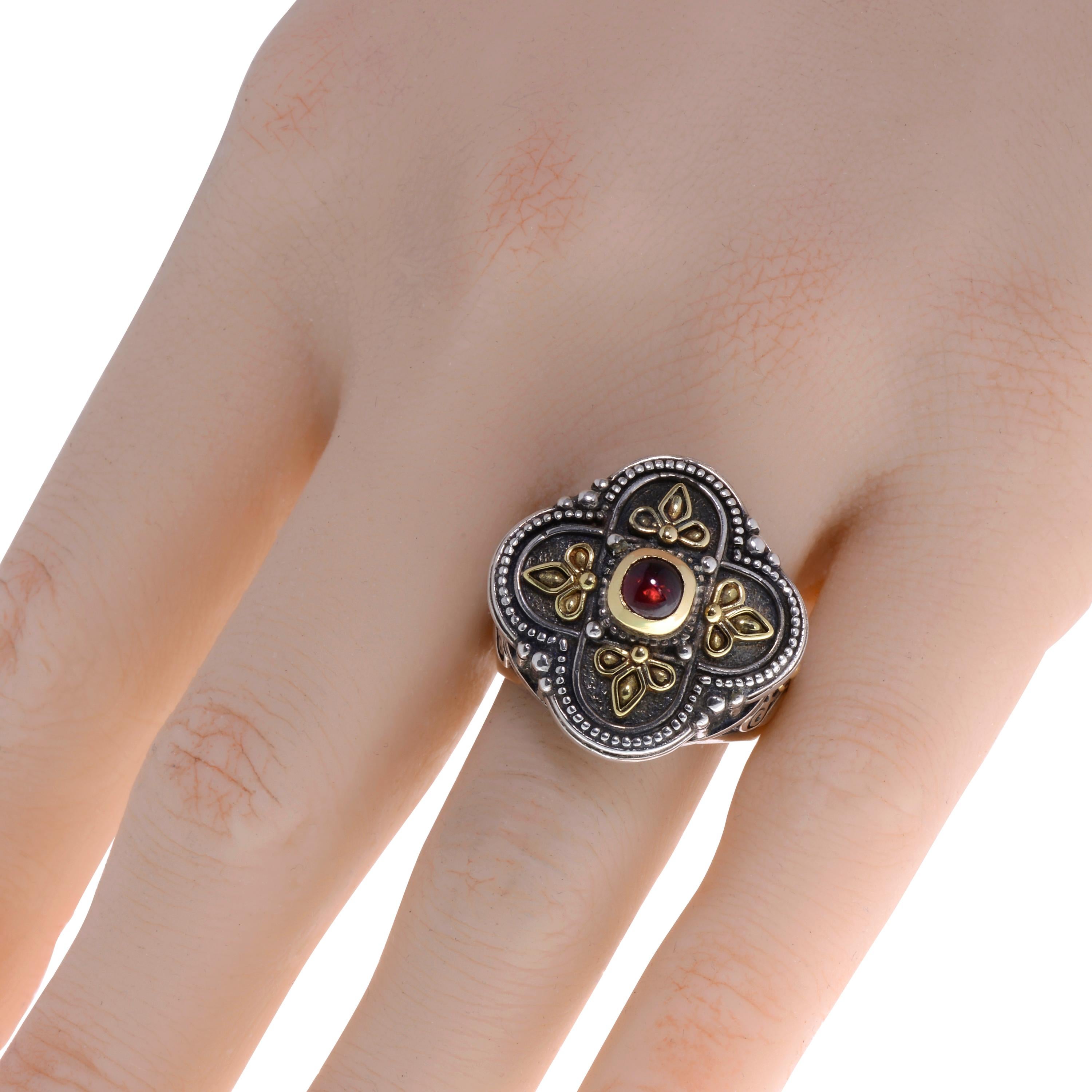 This adventurous Konstantino ring features a cabochon garnet set in 18K yellow gold on an engraved and oxidized sterling silver band. The decoration size is 7/8”. The weight is 19g. The ring size is 7.75 (56.4). 
