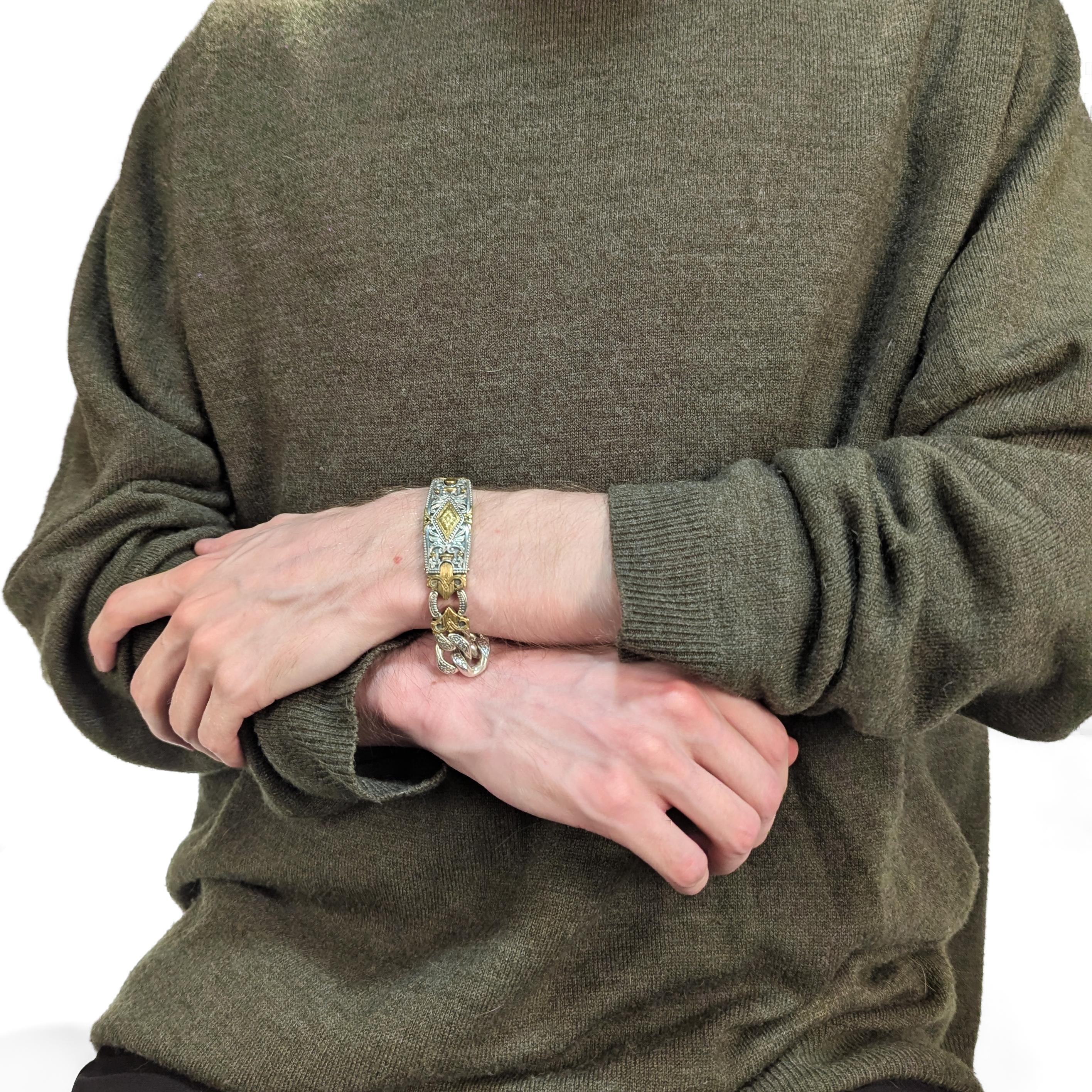 Un fino brazalete griego de plata y oro firmado.

Por Konstantino. 

En plata de ley con placa de bronce.

Tiene un panel central con diseño de espada de bronce, pesados eslabones de cadena de bordillo y un robusto cierre de caja. Grabado en toda la